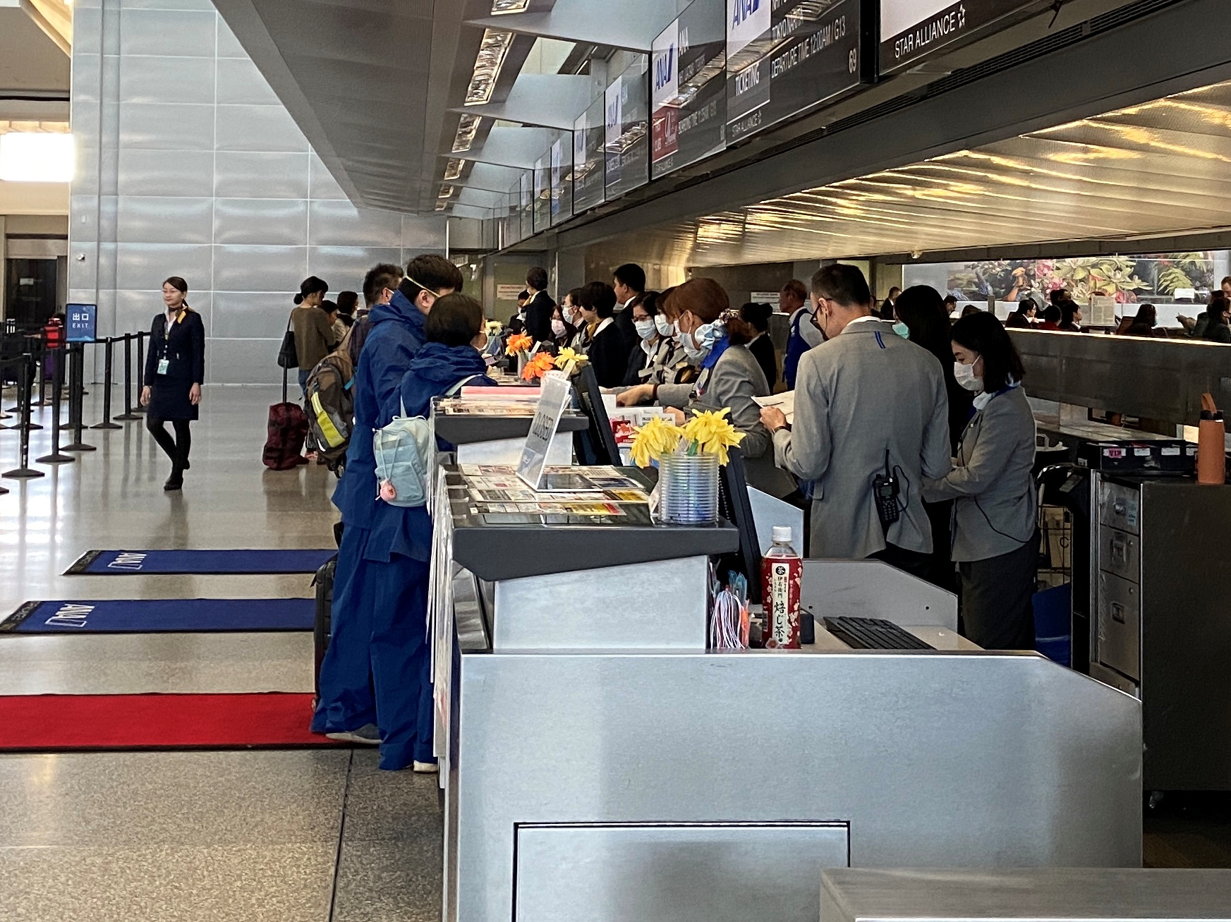 Workers at the ticket desk for Japanese airline All Nippon Airways assist travellers at the departures hall of the San Francisco International Airport, during coronavirus disease (COVID-19) outbreak, in San Francisco