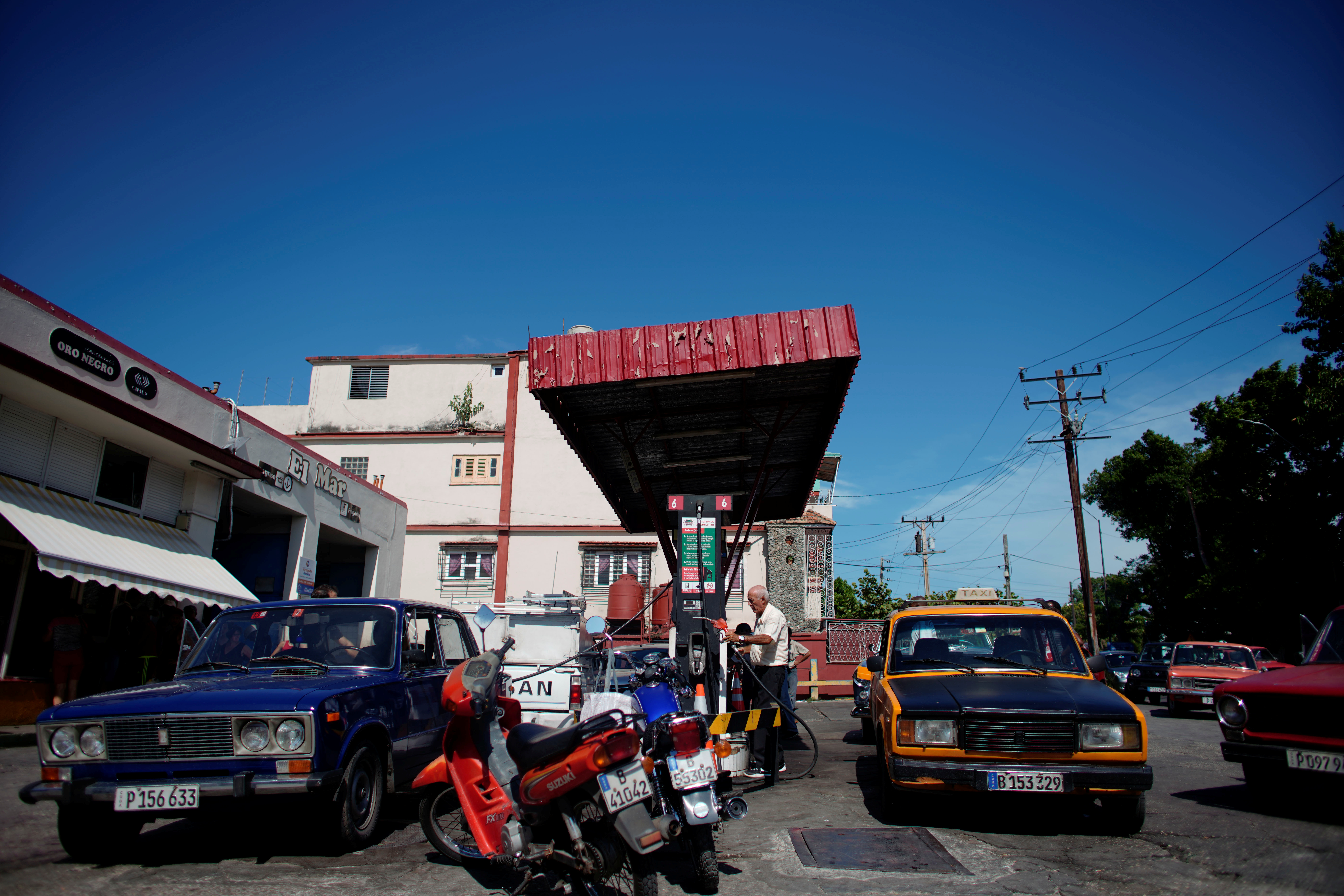 Cars line-up to buy fuel at a gas station in Havana