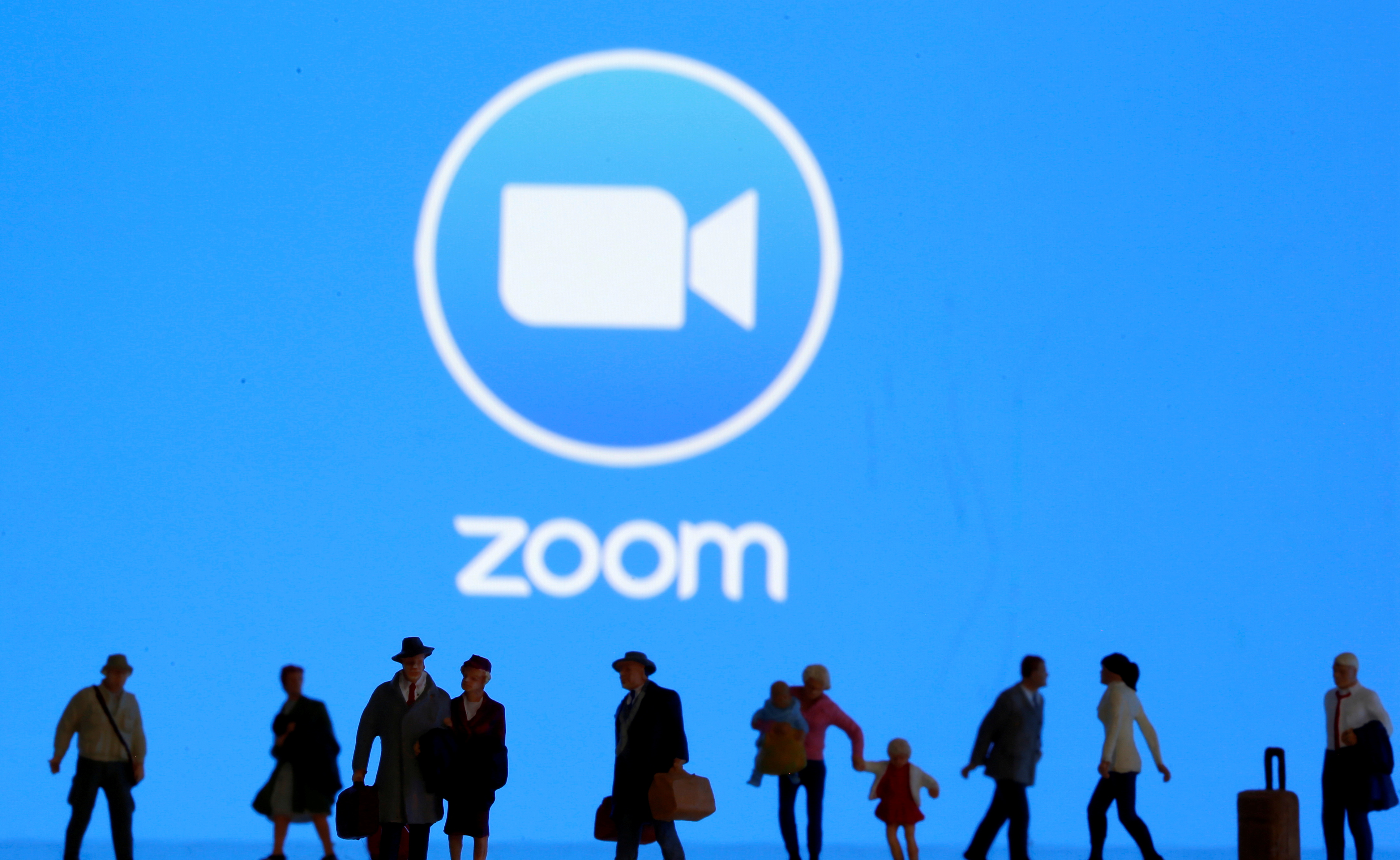 Small toy figures are seen in front of diplayed Zoom logo in this illustration taken March 19, 2020. REUTERS/Dado Ruvic/Illustration