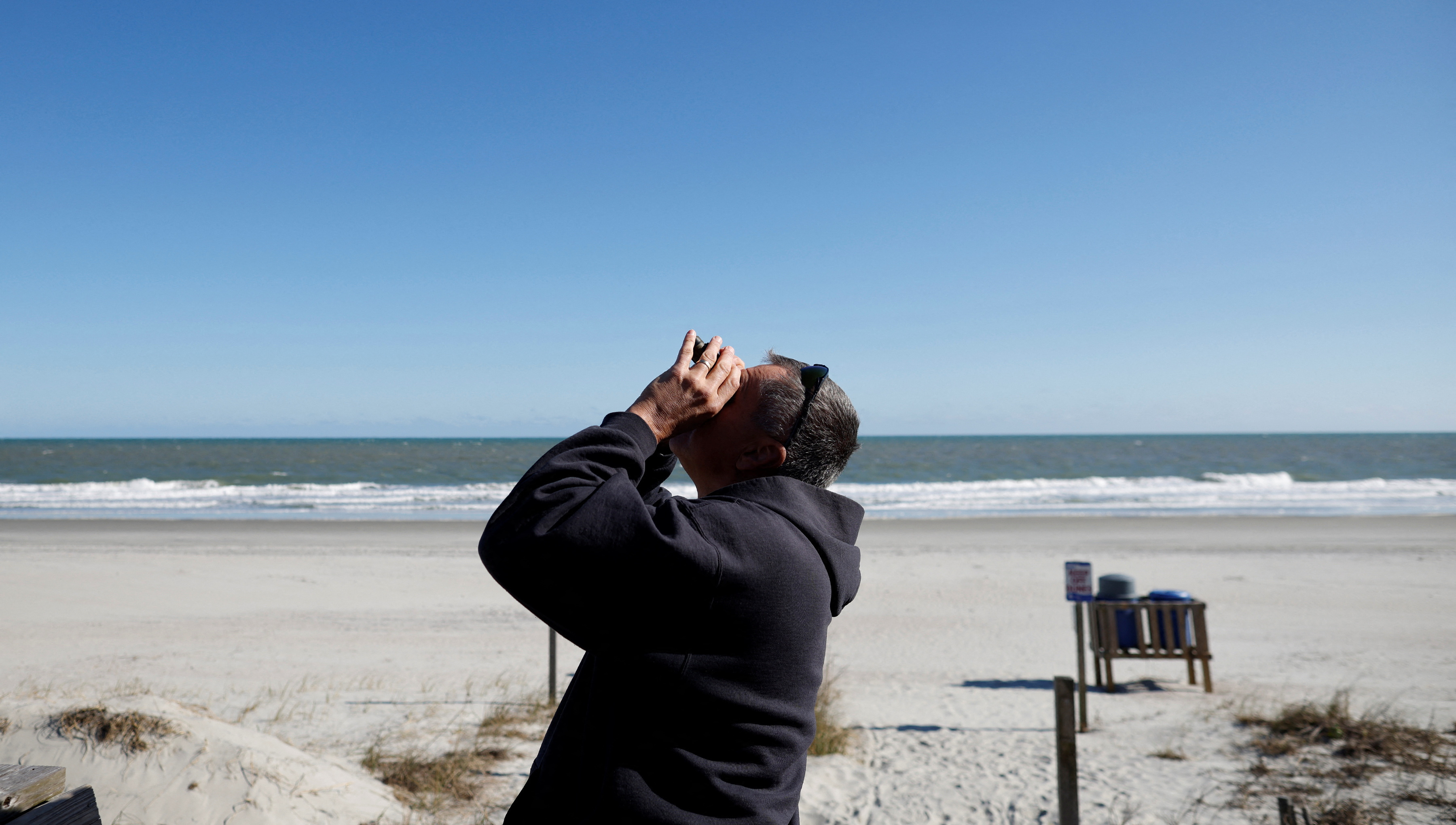 A man checks out a suspected Chinese spy balloon as it floats off the coast in Surfside Beach