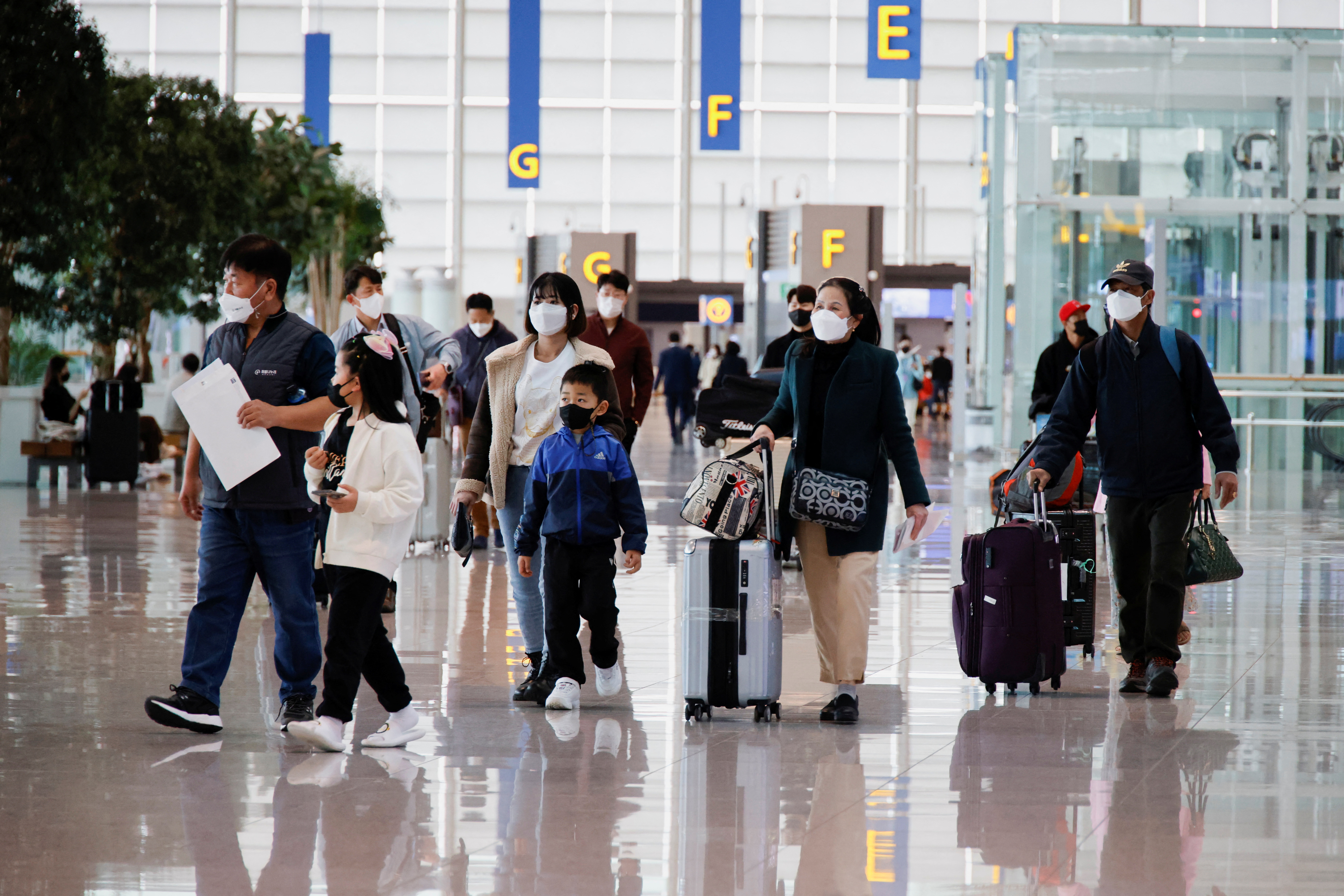 People wearing face masks to prevent contracting from the coronavirus disease (COVID-19) walk at Incheon International Airport in Incheon, South Korea