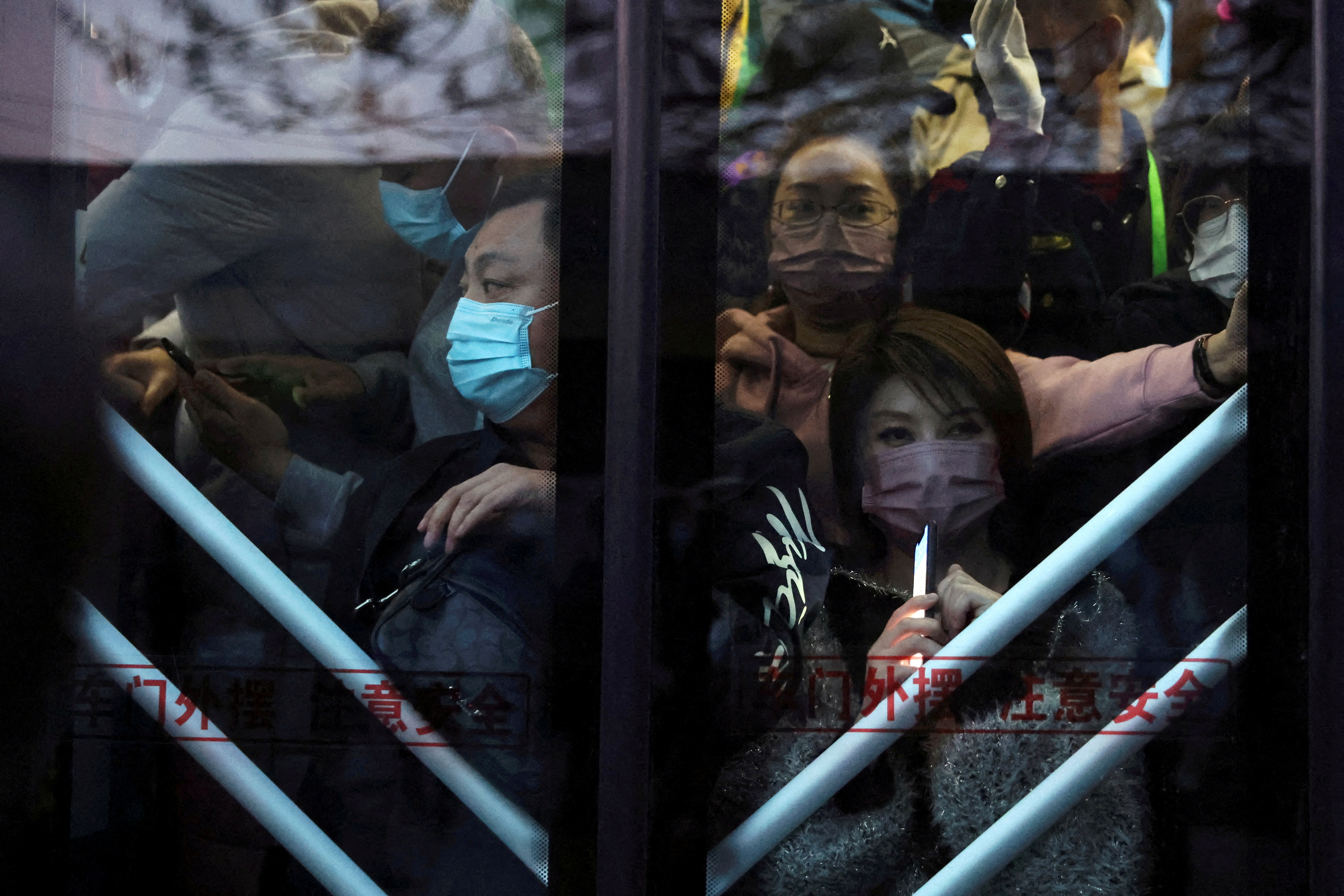 Commuters stand on a bus in the early morning, near a border checkpoint with Hebei province, in Beijing