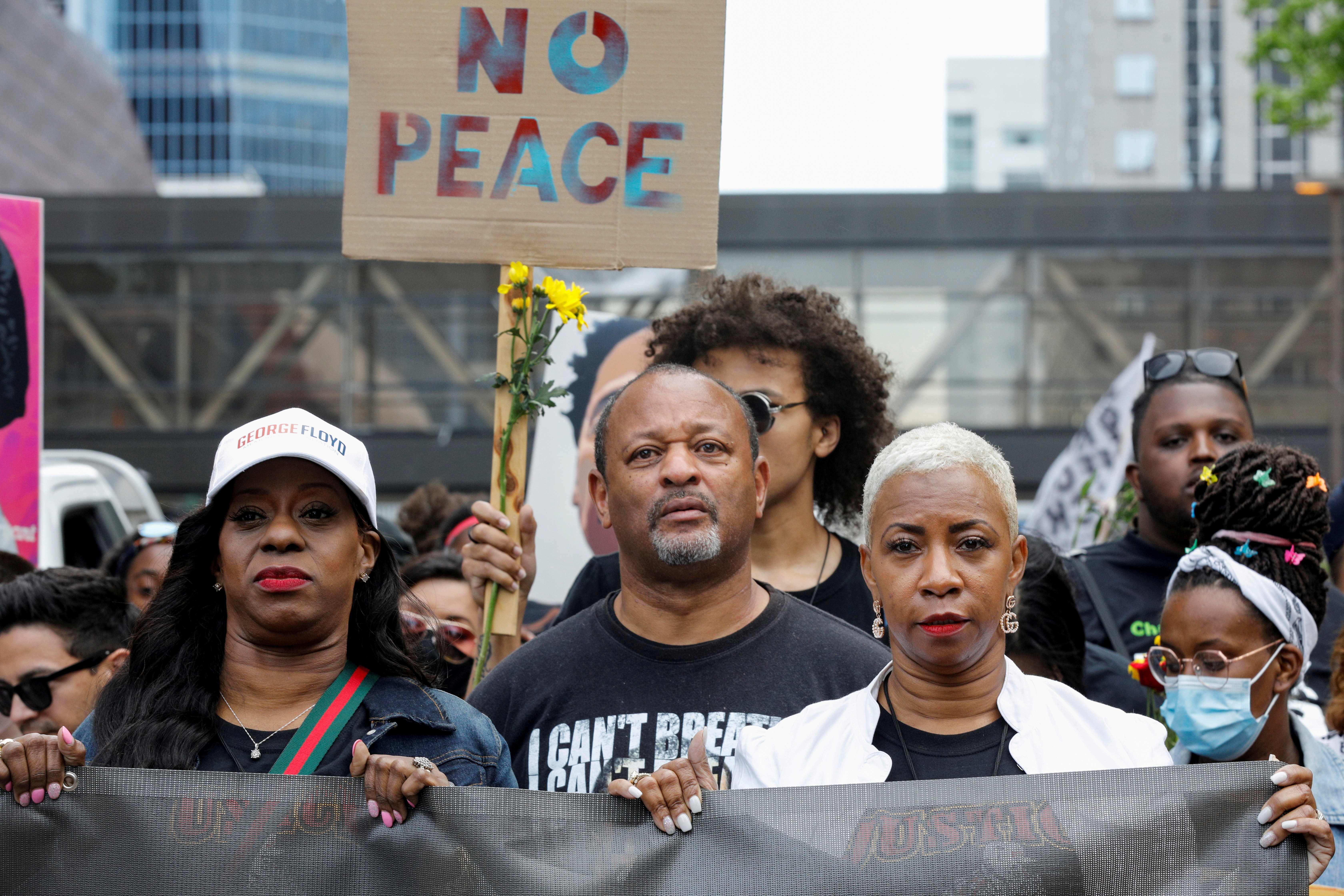 George Floyd's cousin Shareeduh Tate (front R) holds a banner while marching with others during the "One Year, What's Changed?" rally hosted by the George Floyd Global Memorial to commemorate the first anniversary of his death, outside the Hennepin County Government Center in Minneapolis, Minnesota, U.S. May 23, 2021. REUTERS/Nicholas Pfosi