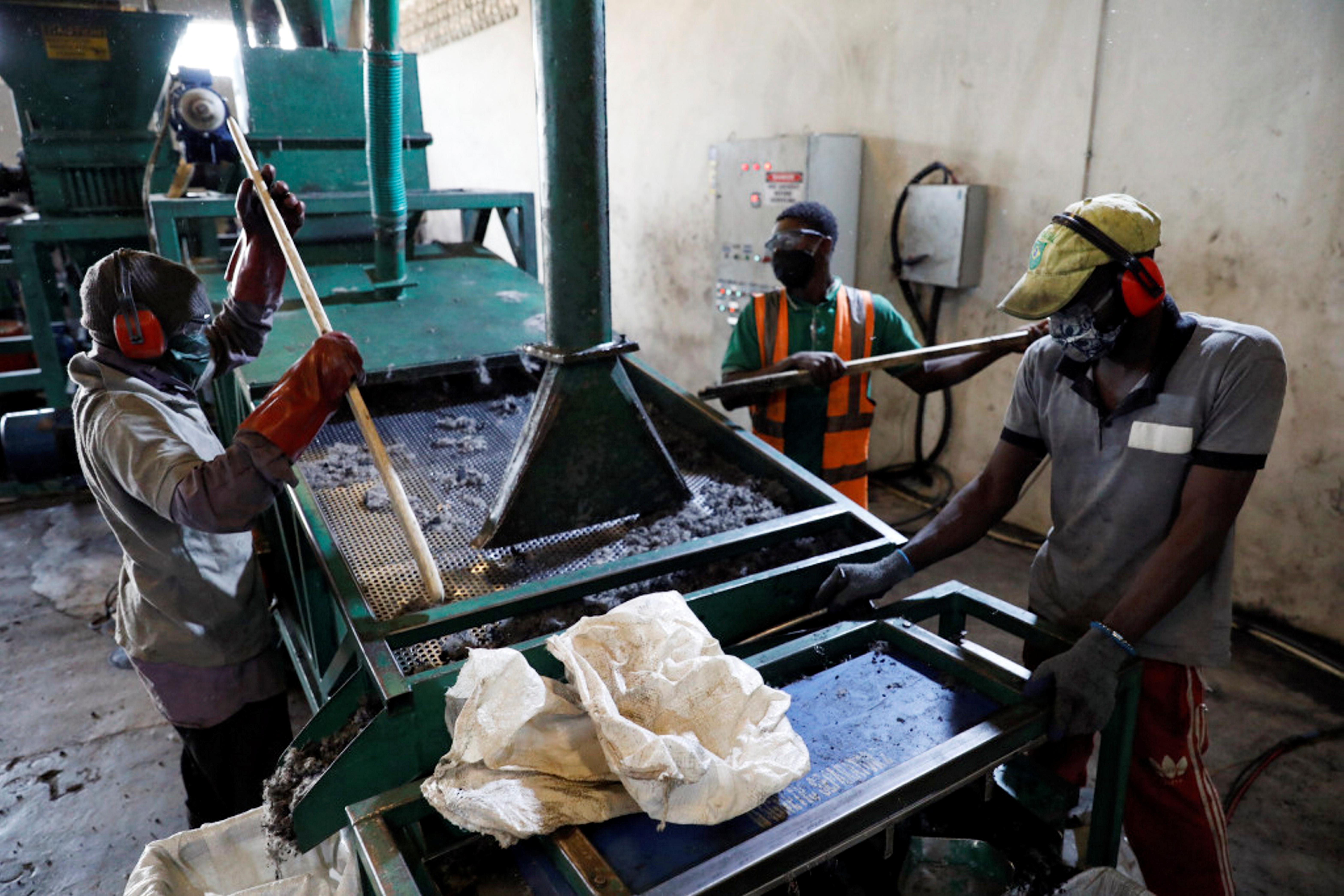 Men work on the recycling line of used car tyres in Ibadan