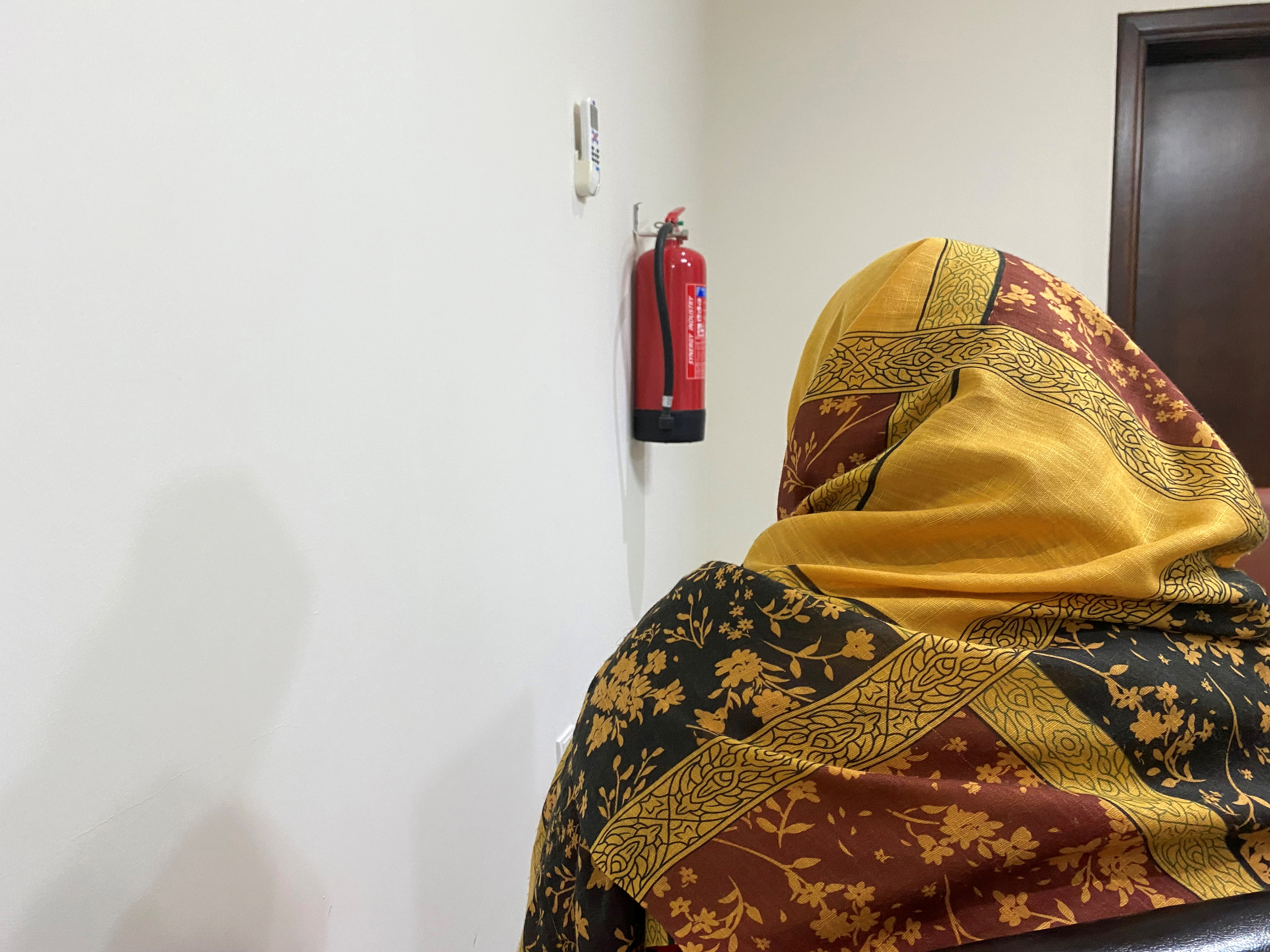 An evacuated Afghan woman speaks during an interview in Doha