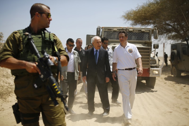 Former Israeli President Peres and New York Governor Cuomo walk together during a tour on the Israel-Gaza border