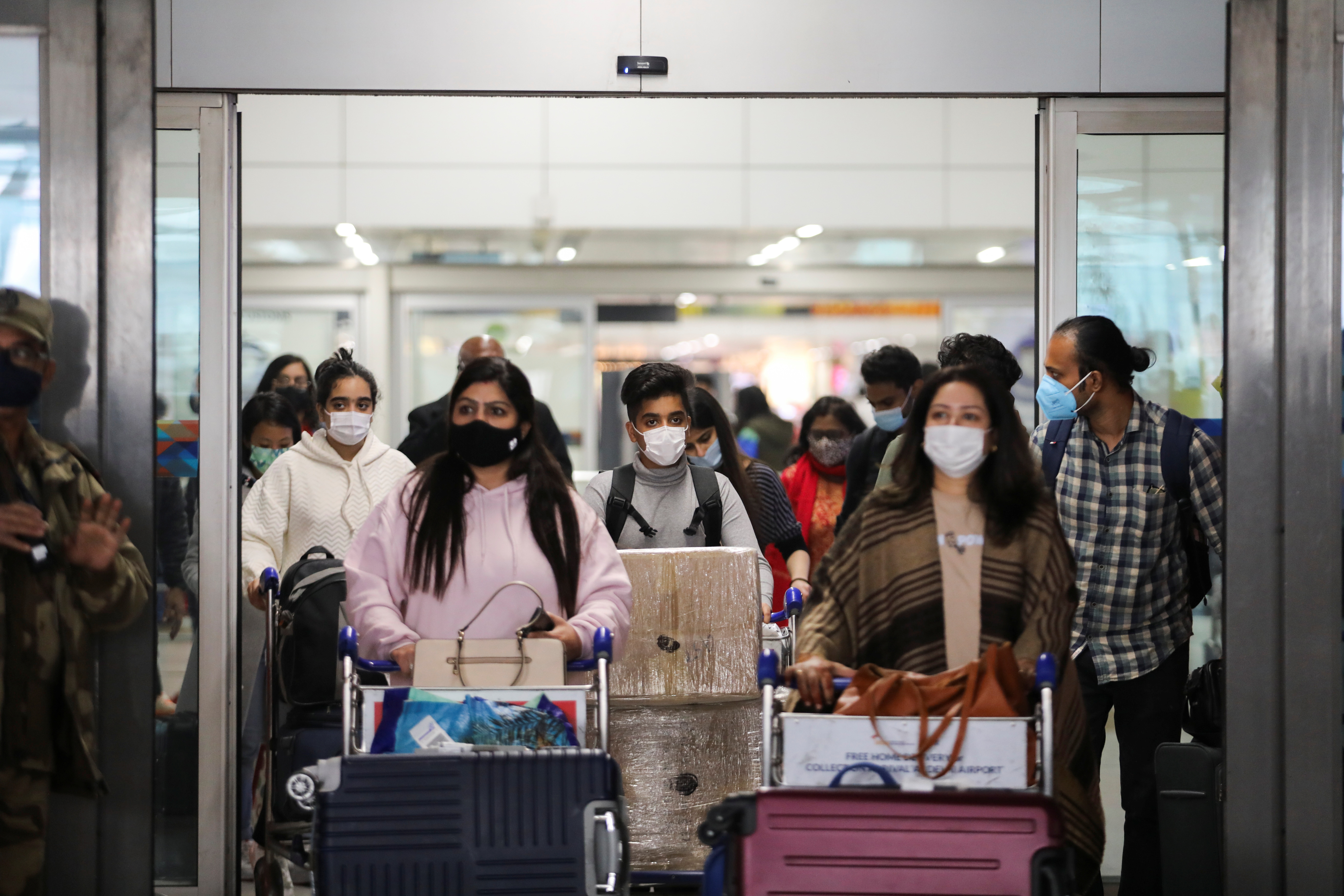 People exit from the arrival section of the Indira Gandhi International Airport in New Delhi, India, December 3, 2021. REUTERS/Anushree Fadnavis