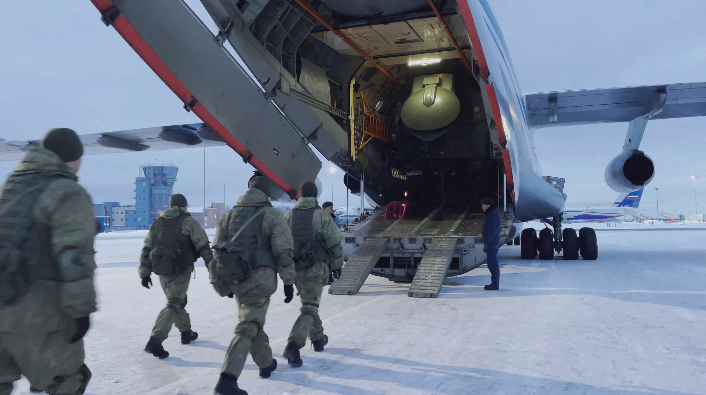 Russian servicemen board a military aircraft heading to Kazakhstan, at an airfield outside Moscow