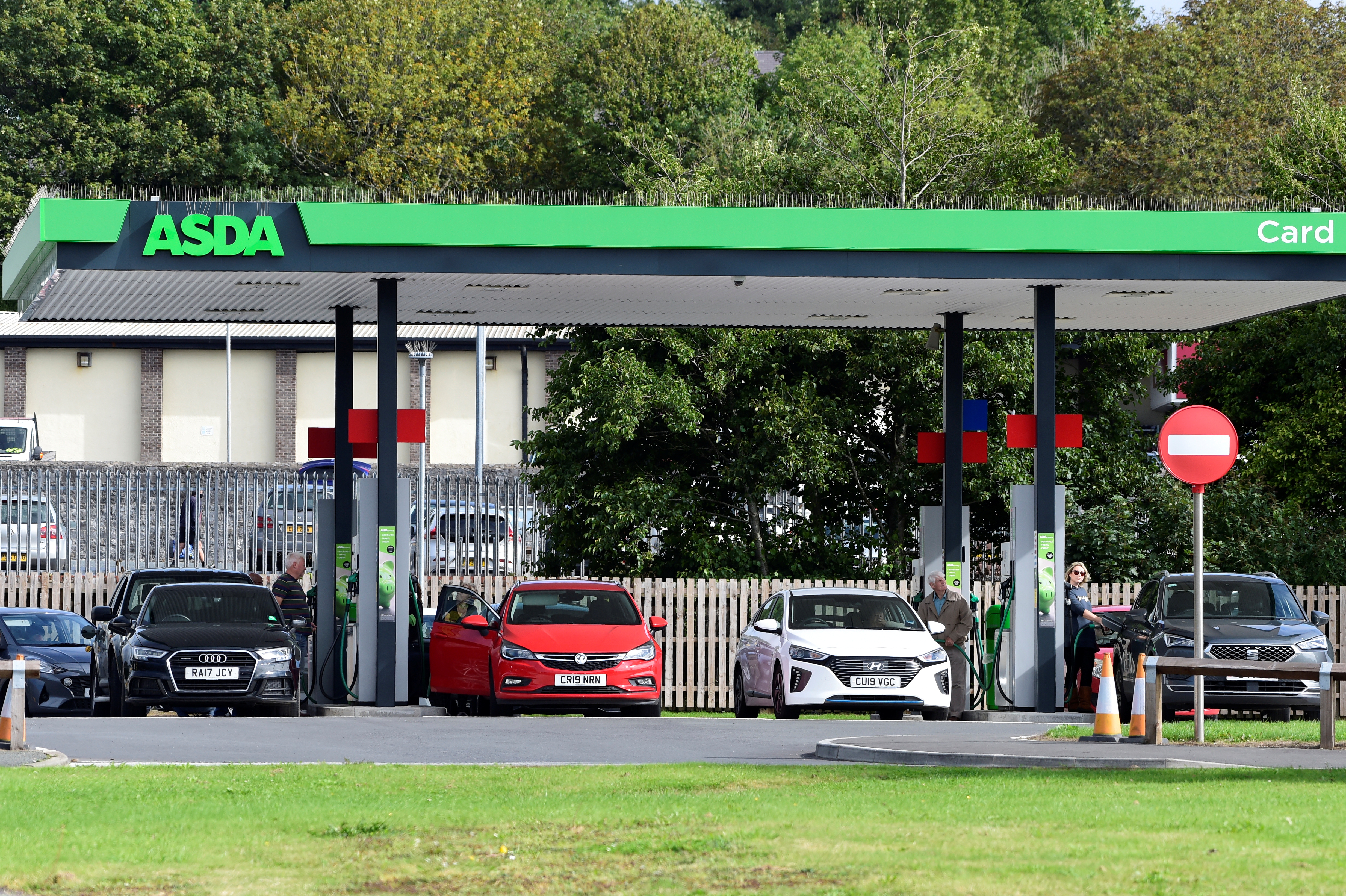Cars wait at a petrol and diesel filling station in Pembroke Dock