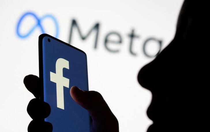 Woman holds smartphone with Facebook logo in front of a displayed Facebook's new rebrand logo Meta in this illustration picture