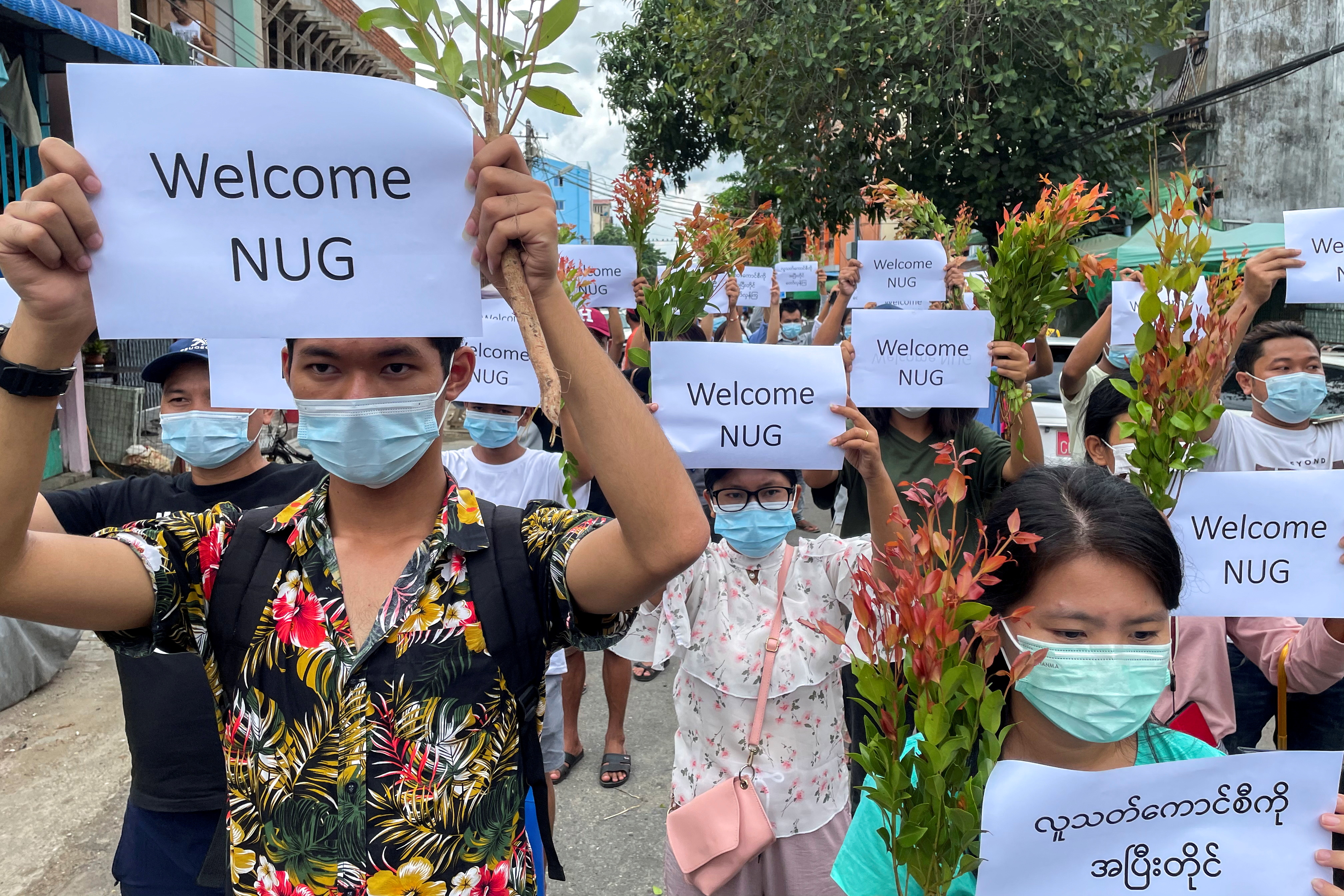 Anti-government protesters hold placards to show their support and welcome the new National Unity Government found by ousted NLD legislators and call to continue strike from traditional new year in Myanmar, in Yangon