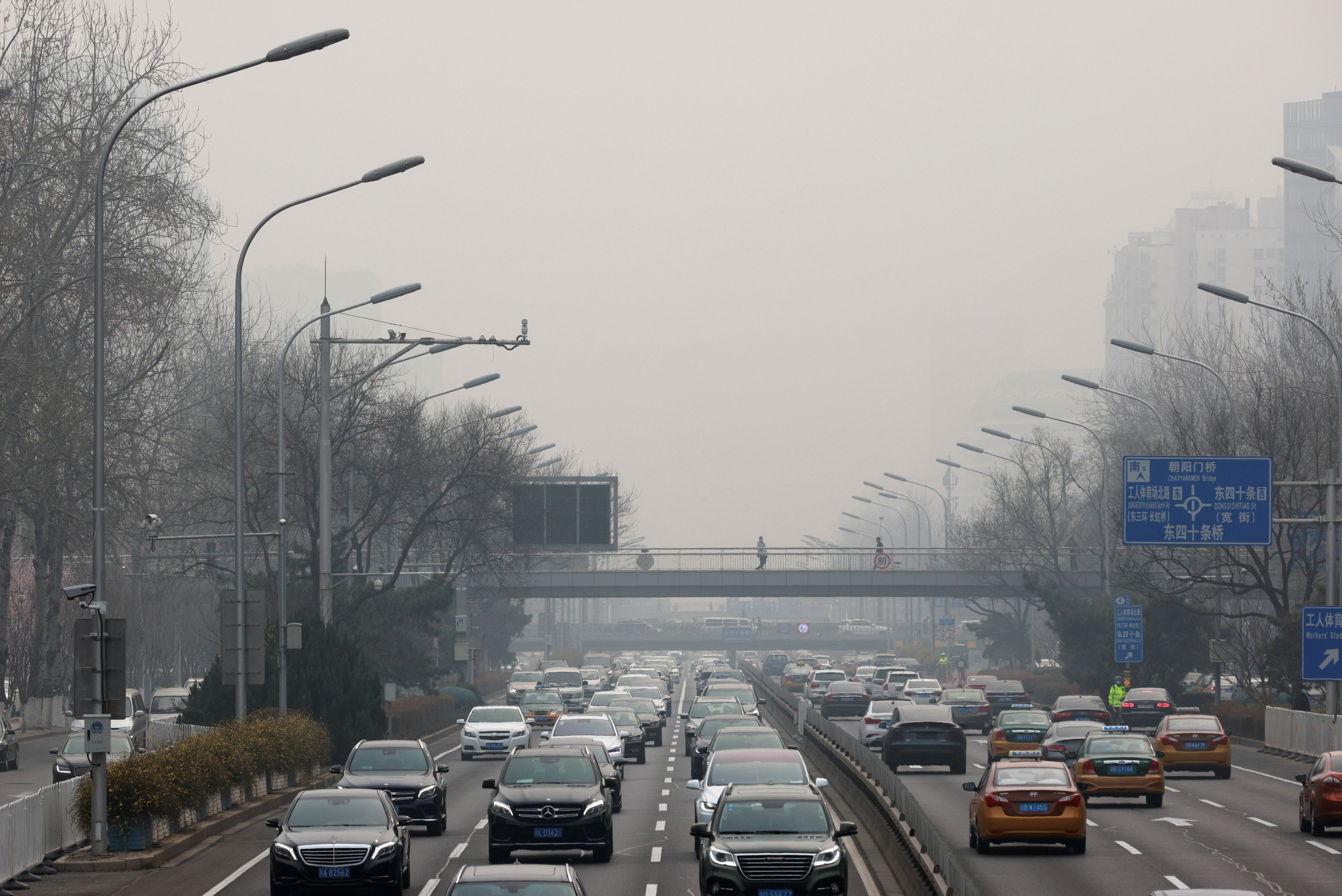 FILE PHOTO: Cars drive in the city centre, on the day of closing session of the Chinese People's Political Consultative Conference (CPPCC), during a polluted day in Beijing, China, March 10, 2021. REUTERS/Thomas Peter/File Photo