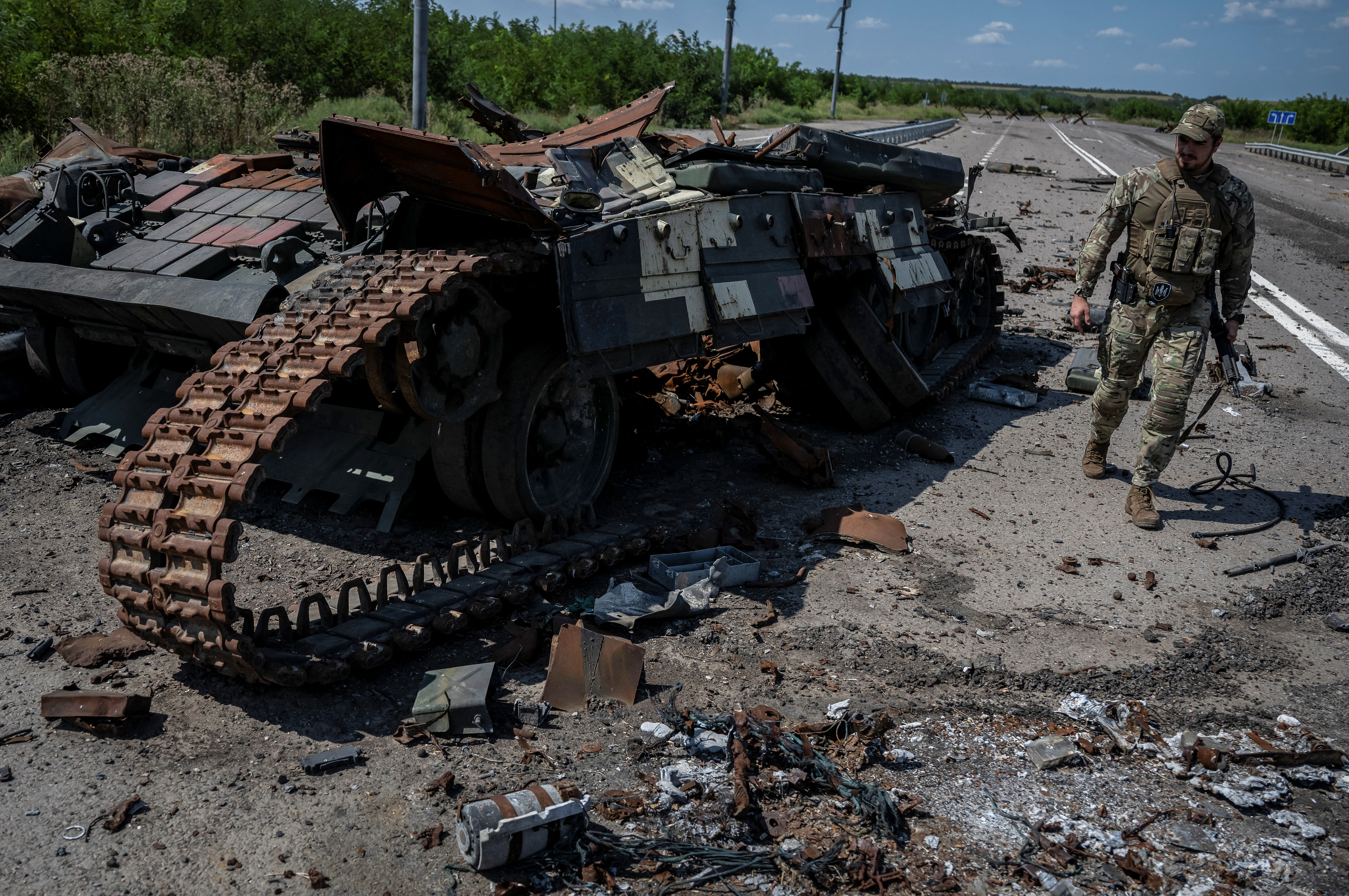 A Ukrainian serviceman walks near a destroyed Ukrainian tank near the village of Robotyne