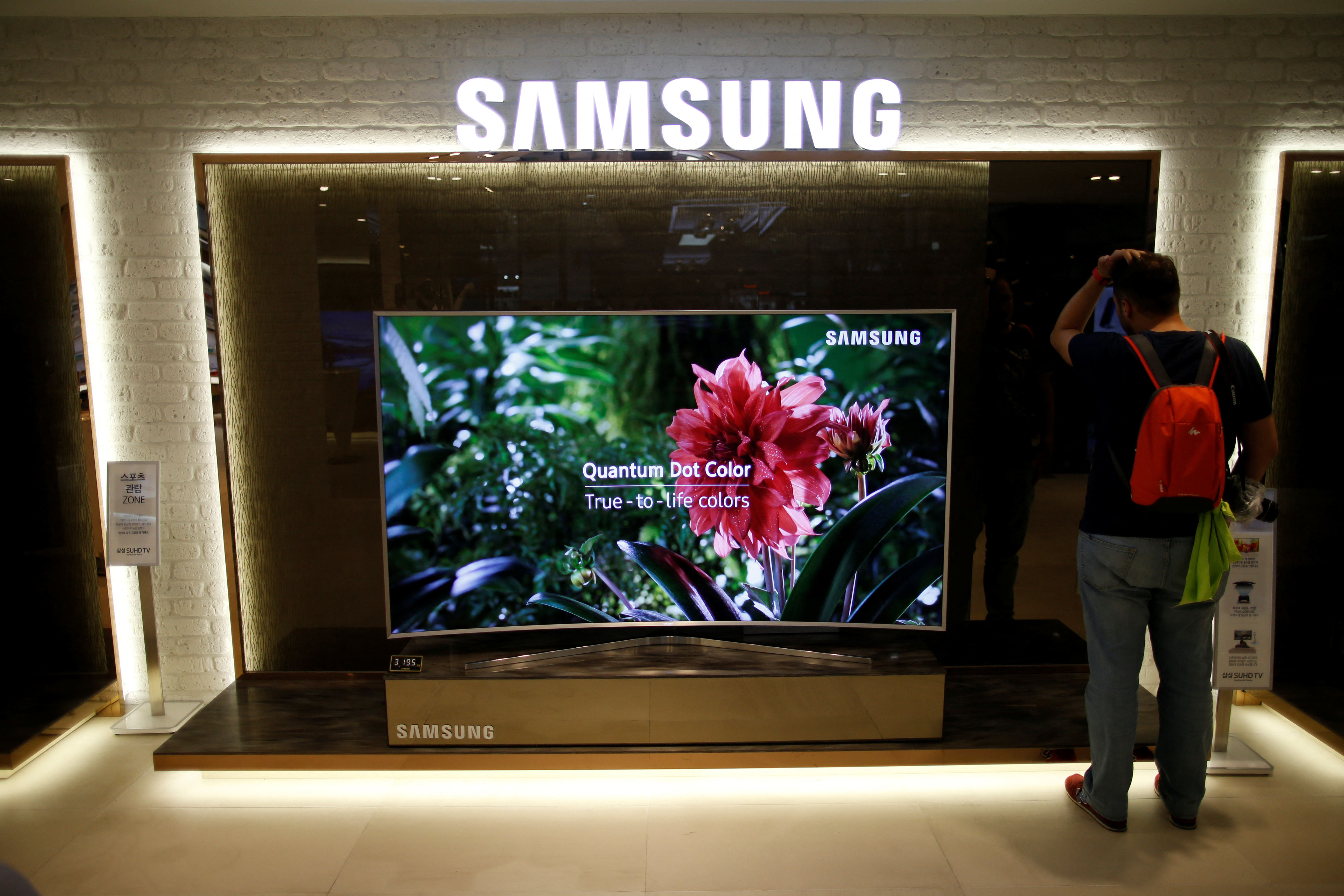 A man stands next to a Samsung Electronics 
