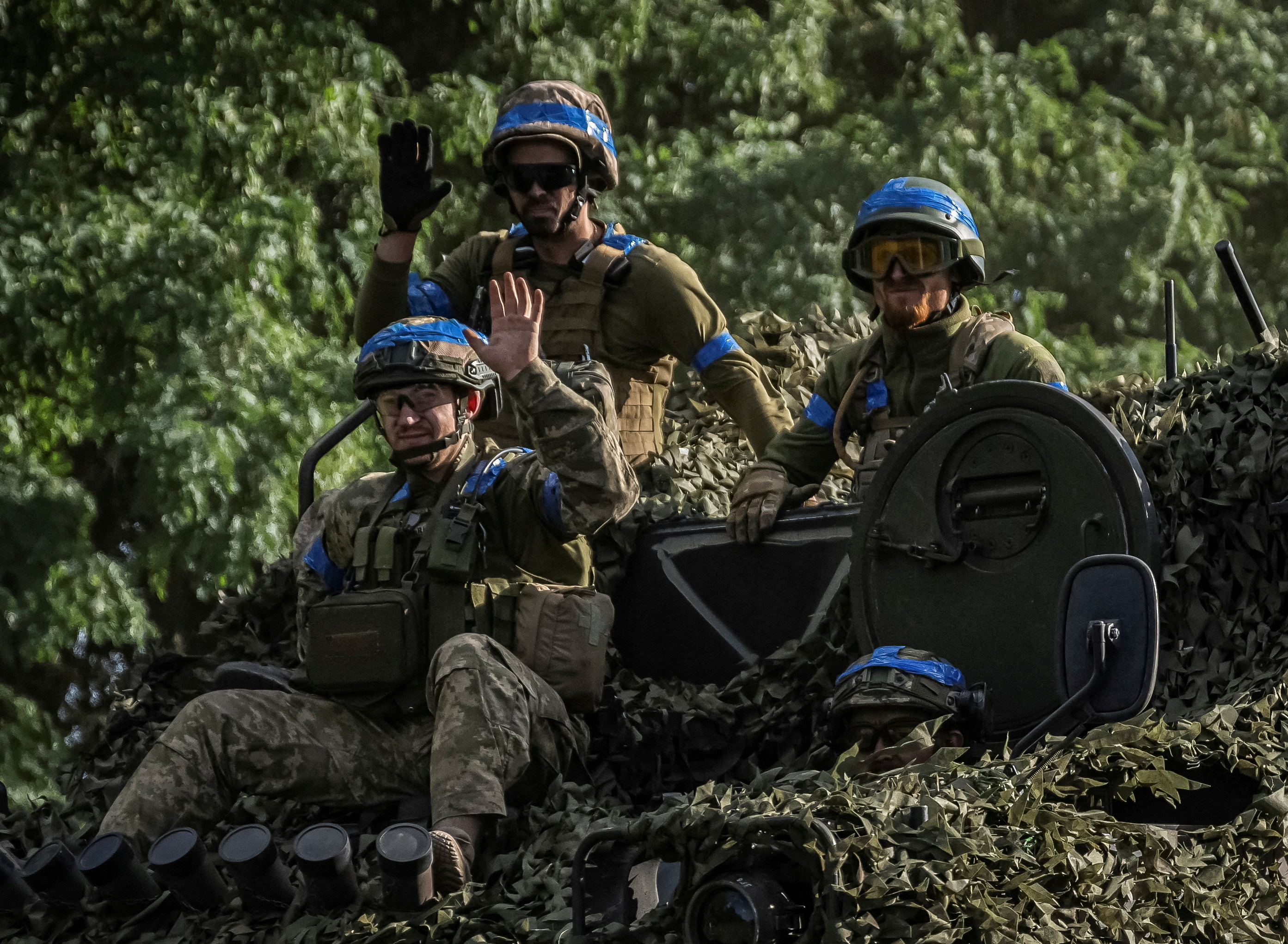 Ukrainian service members ride an Armoured Personnel Carrier near the Russian border in Sumy region