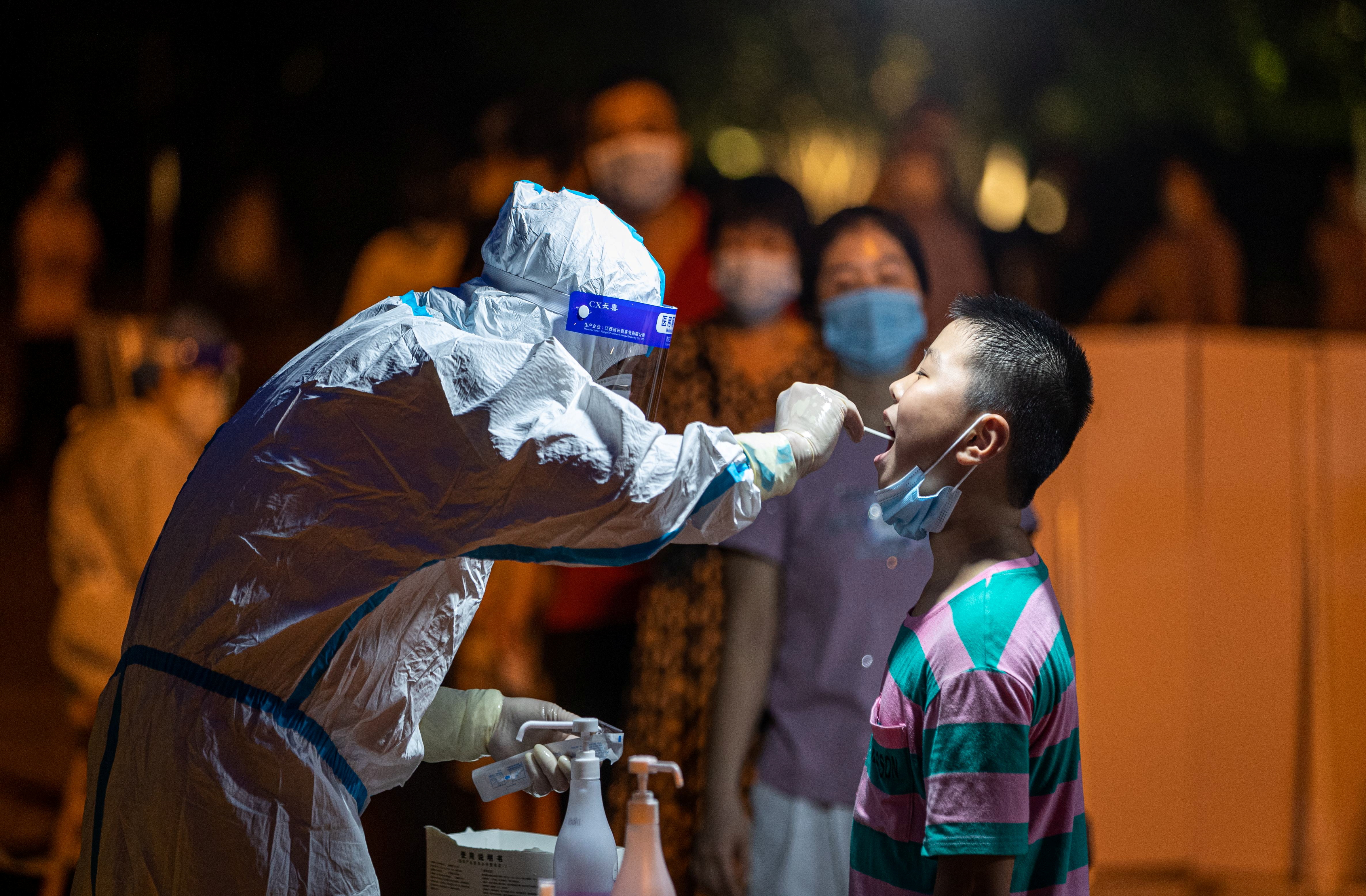 Medical worker collects a swab from a resident during a mass nucleic acid testing, following new cases of the coronavirus disease (COVDI-19), in Fujian