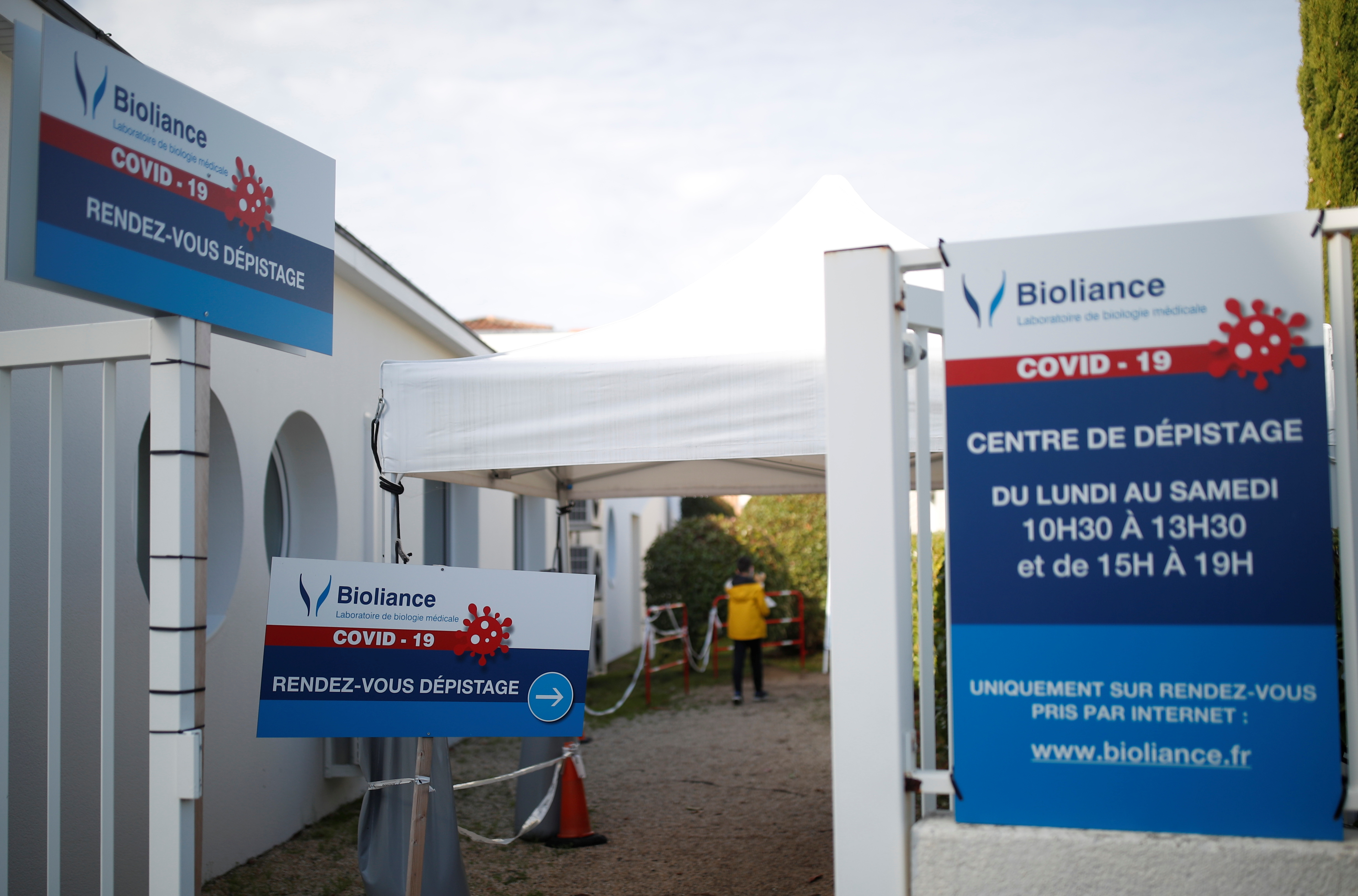 A patient walks at the entrance of a coronavirus disease (COVID-19) testing centre in Les Sorinieres