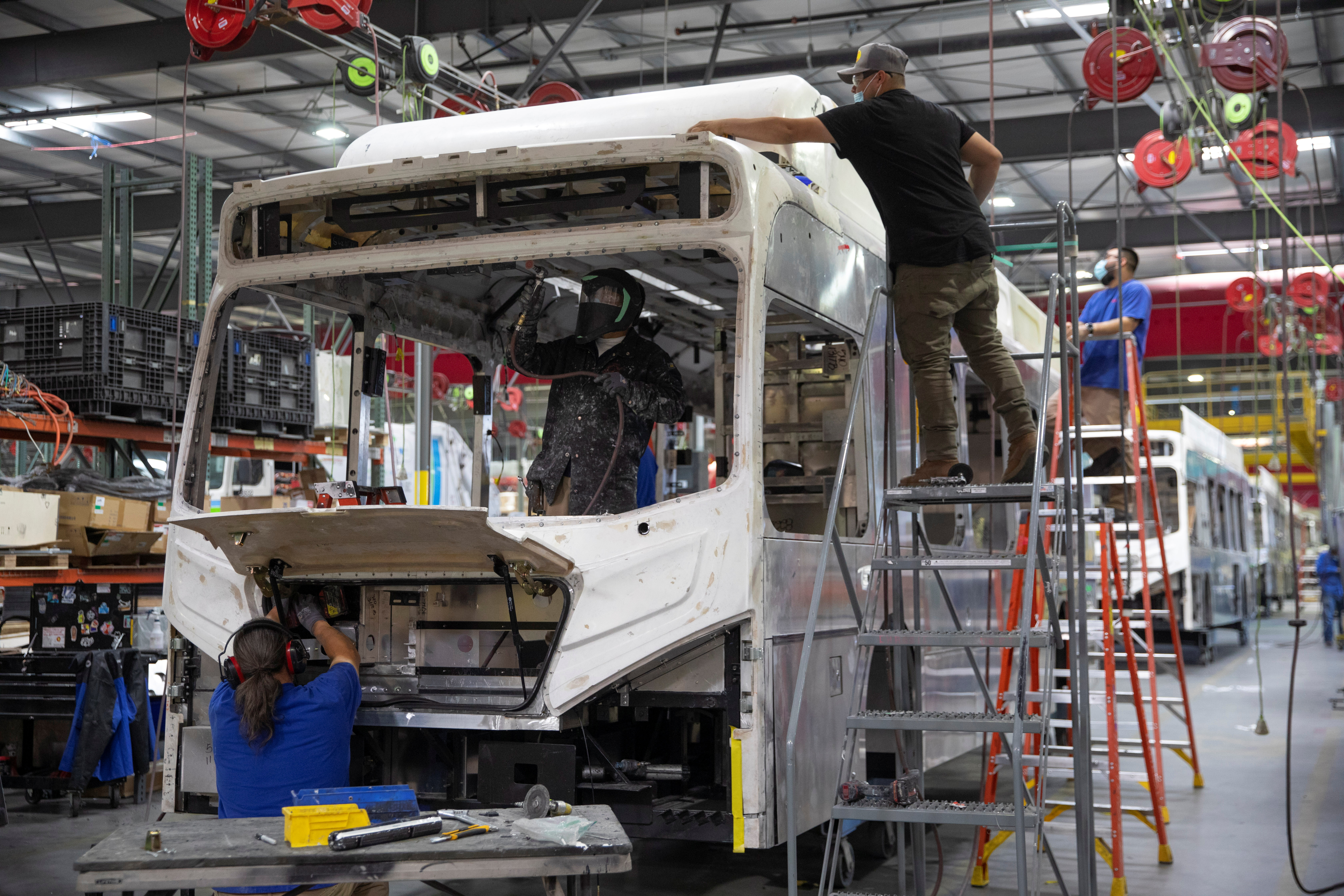 Workers build electric buses at the BYD electric bus factory in Lancaster, California