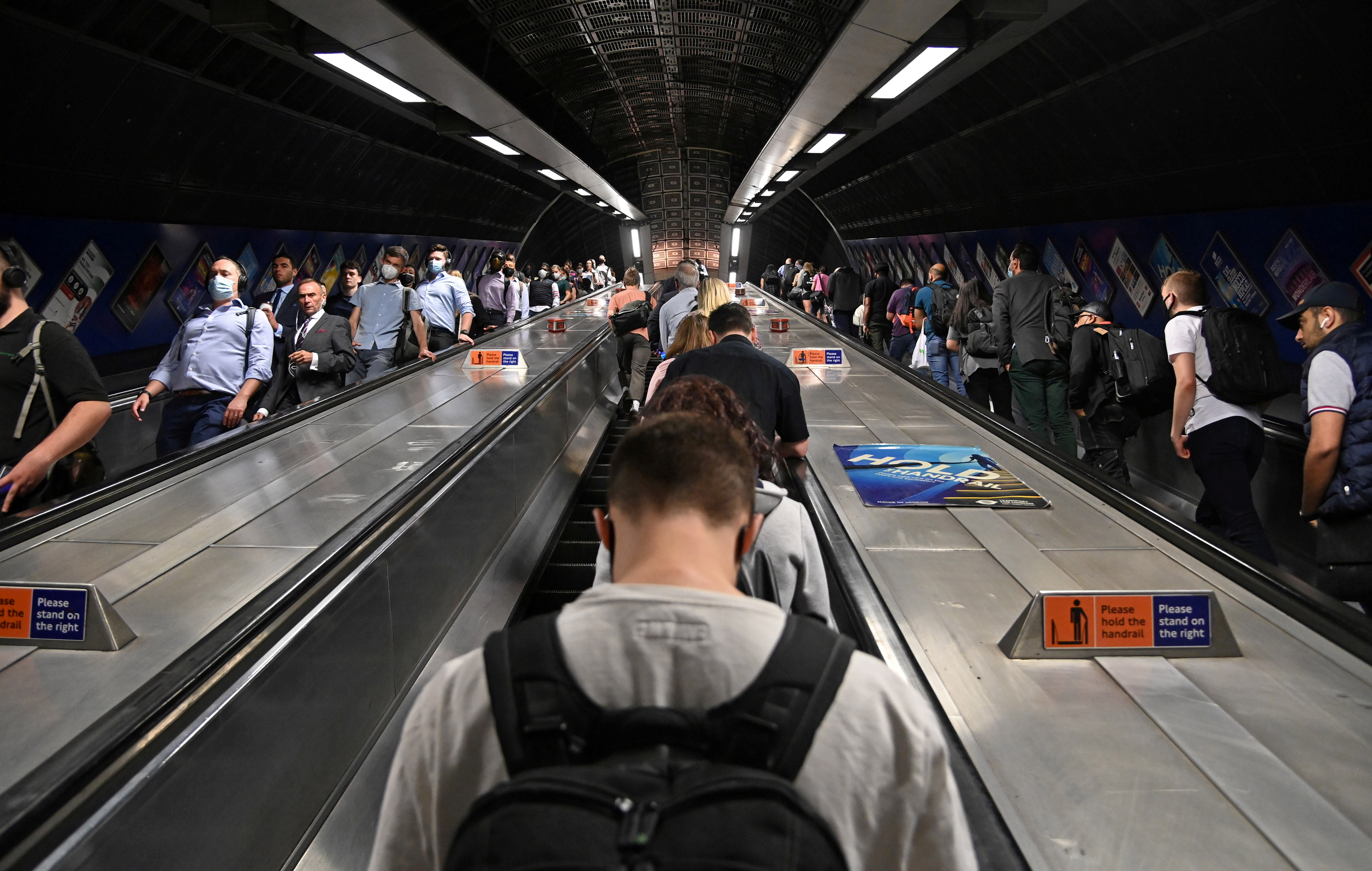 Workers travel through London Bridge rail and underground station during the morning rush hour in London, Britain, September 8, 2021. REUTERS/Toby Melville/Files