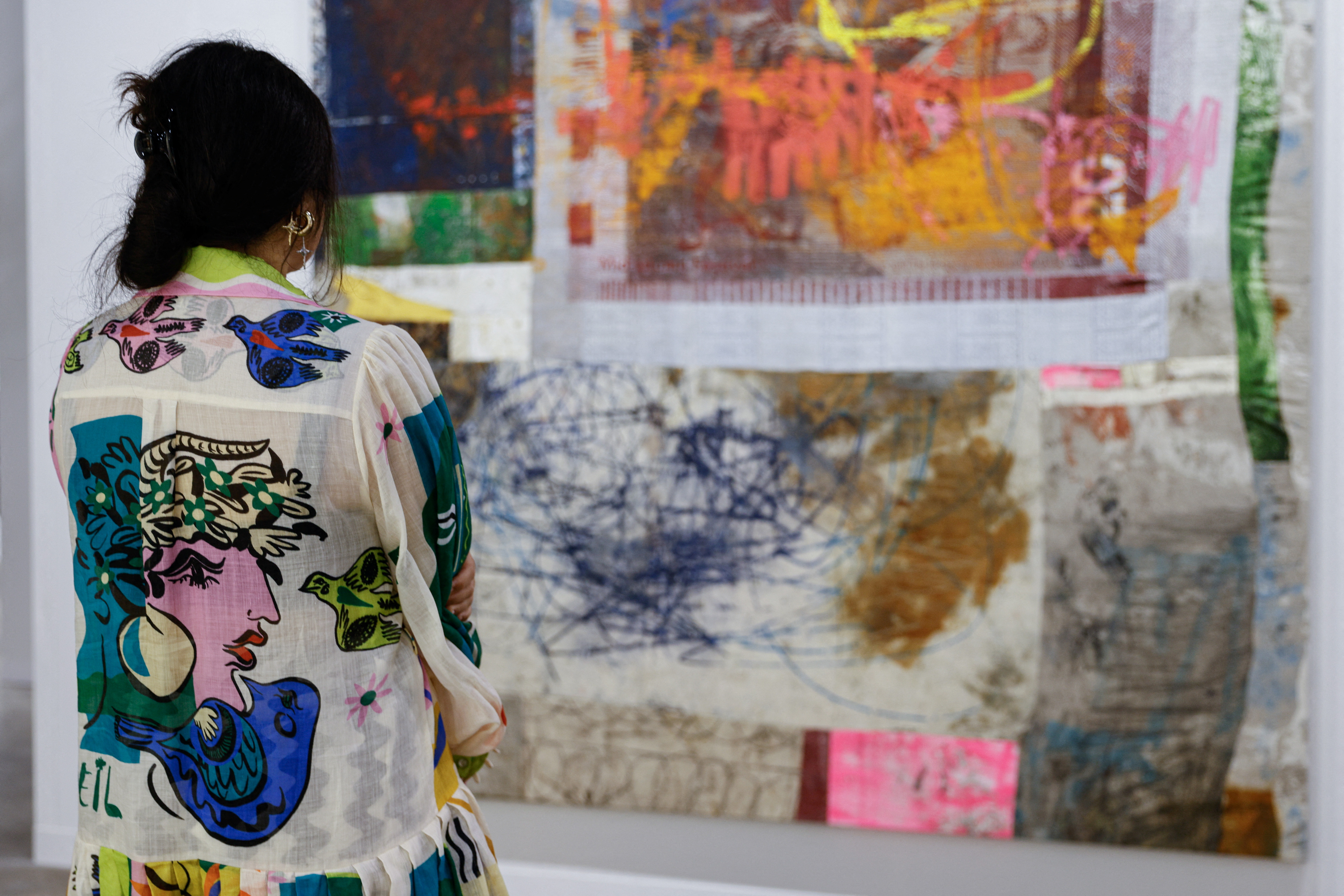 A woman looks at an artwork titled 