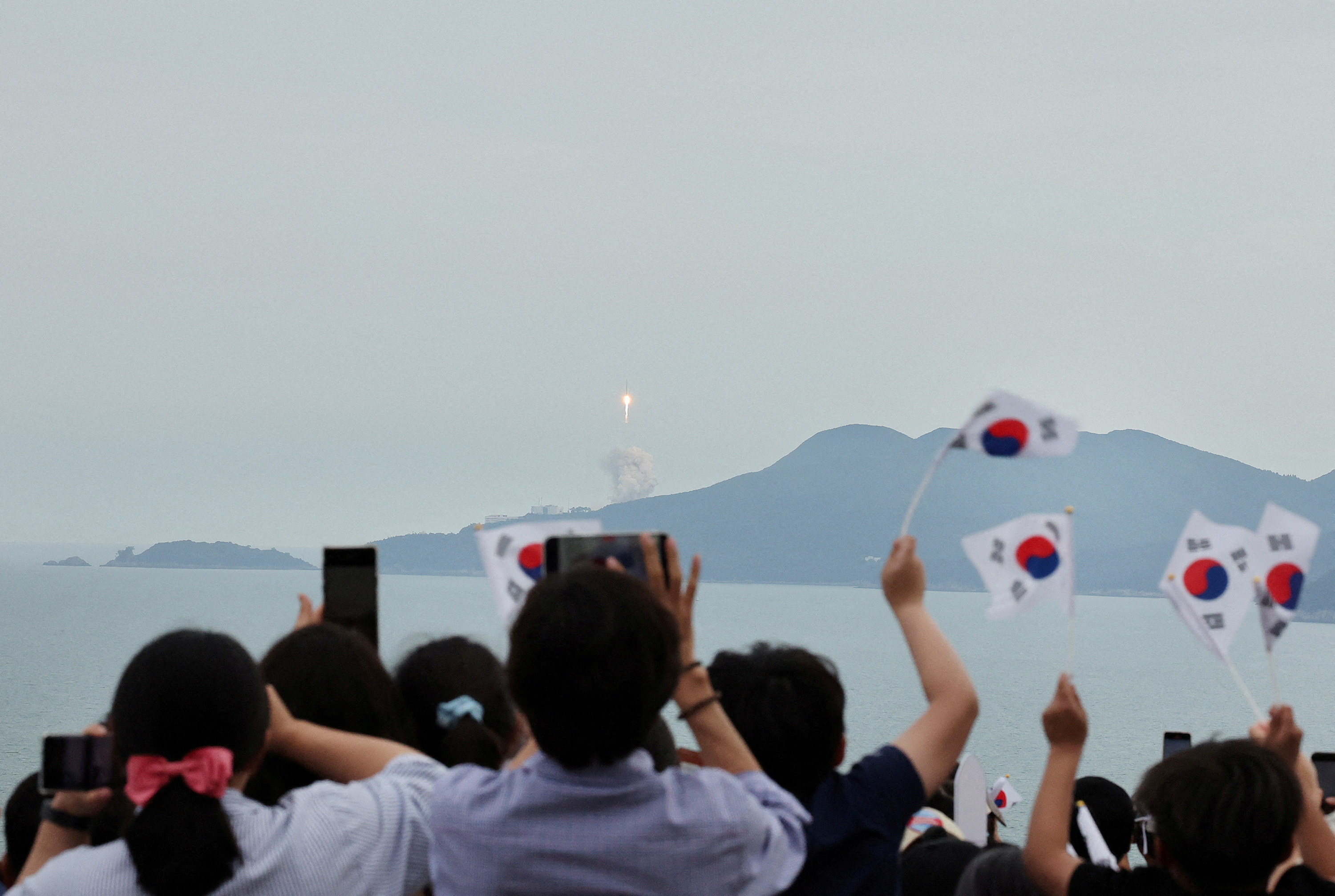 People watch the launch of South Korea�s homegrown Nuri space rocket in Goheung