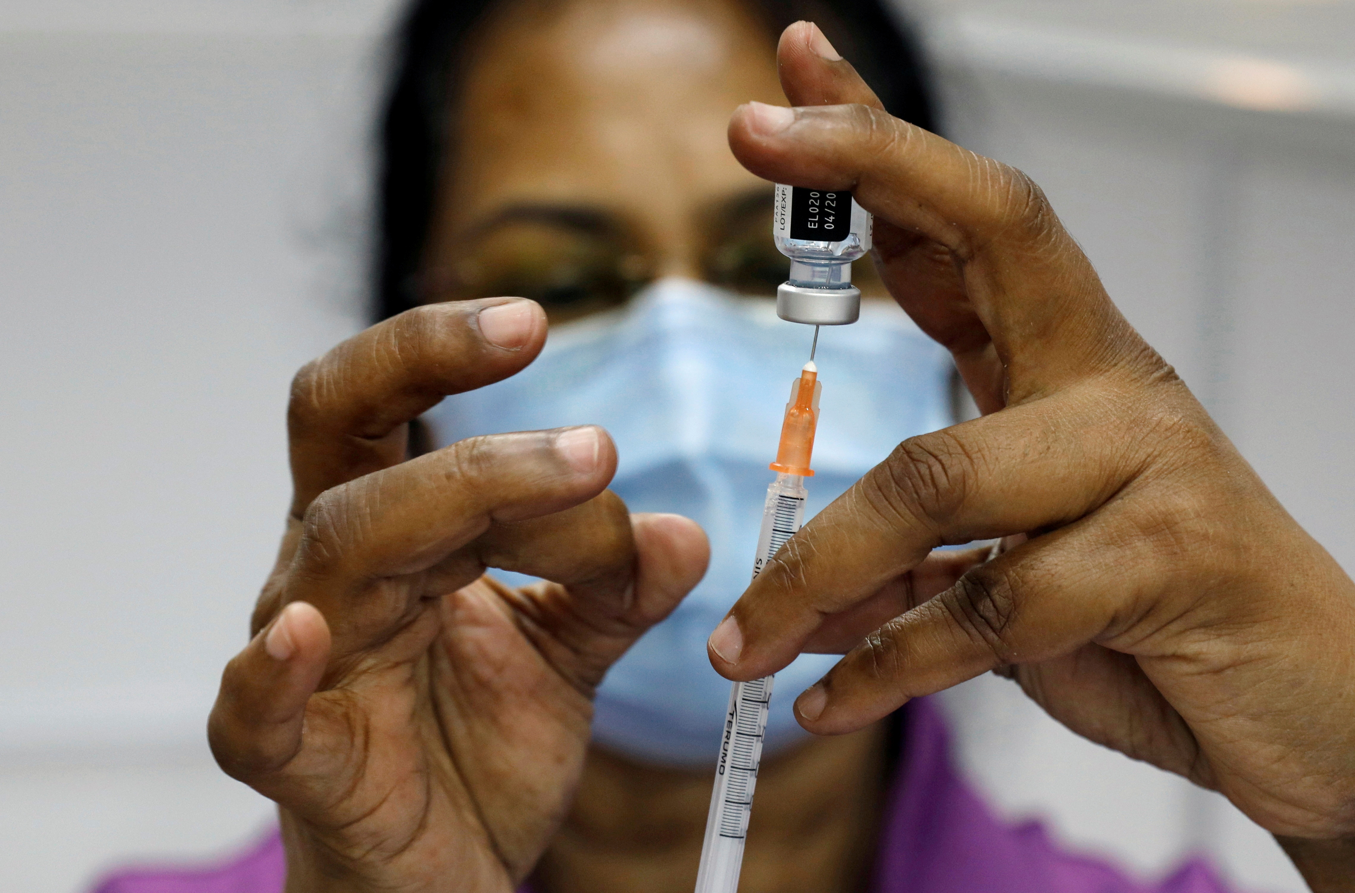 A medical worker prepares a syringe at a coronavirus disease (COVID-19) vaccination center in Singapore, March 8, 2021. REUTERS/Edgar Su/File Photo