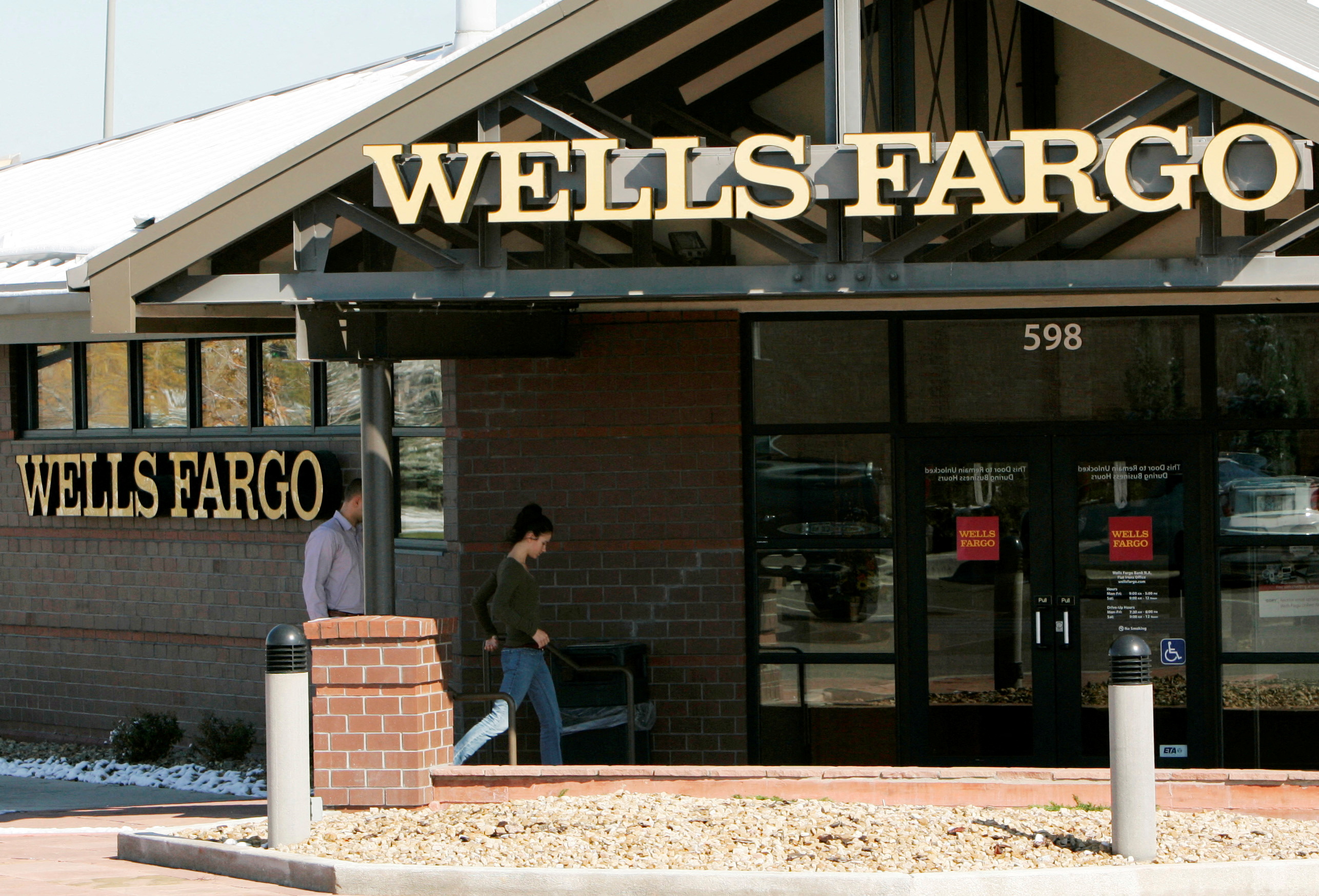 Customers walk into a Wells Fargo bank branch in suburban Denver, Colorado October 18, 2006. REUTERS/Rick Wilking