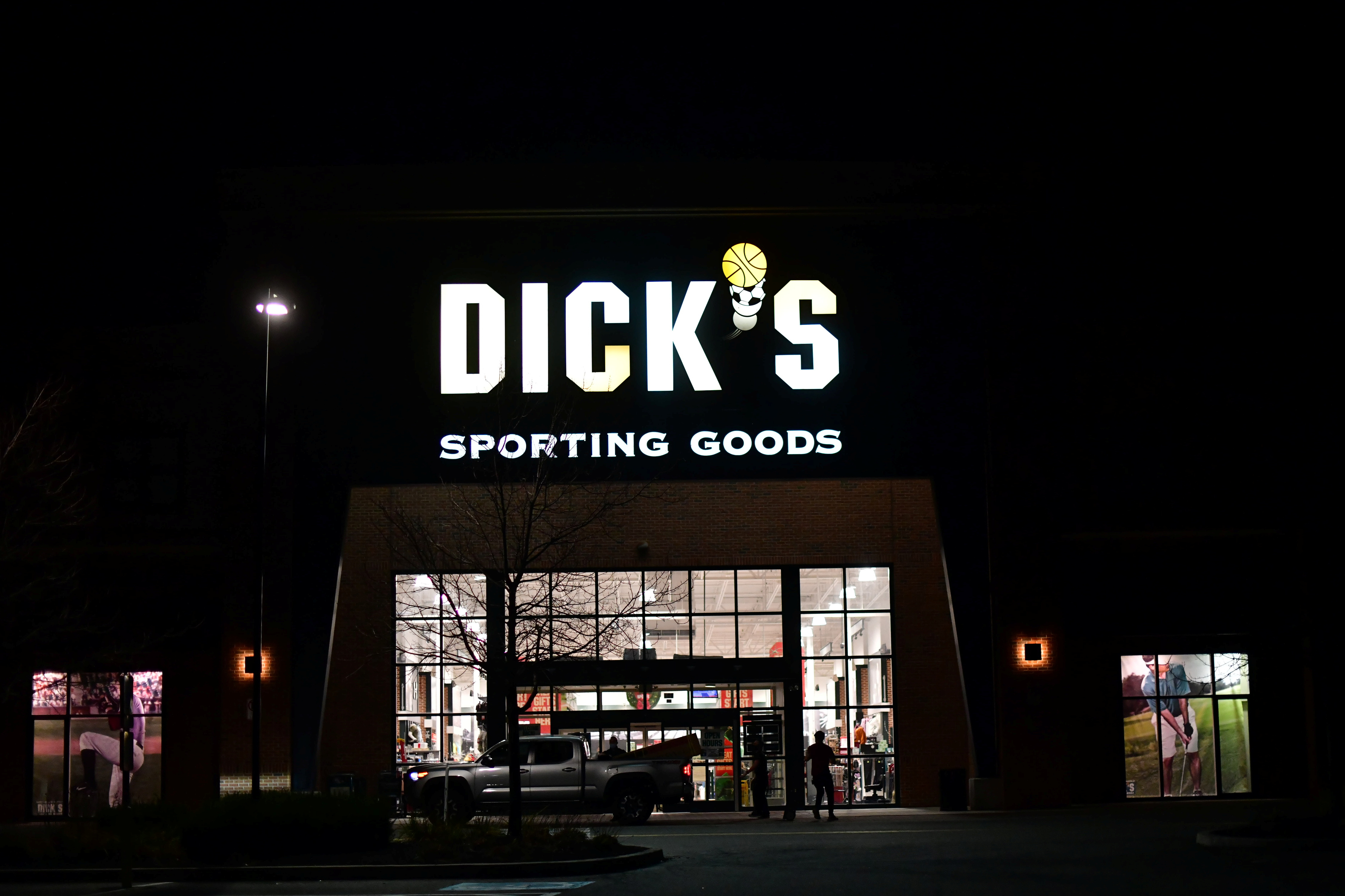 Shoppers load purchased merchandise into a truck outside a Dick's Sporting Goods store in Collegeville