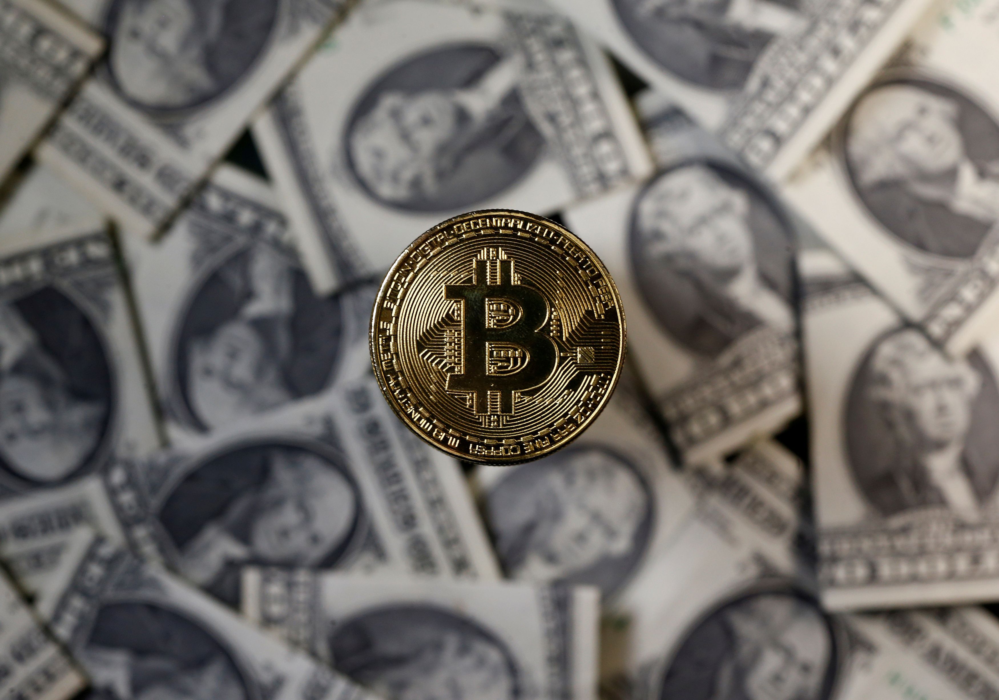 A bitcoin (virtual currency) coin placed on Dollar banknotes is seen in this illustration picture, November 6, 2017. REUTERS/Dado Ruvic/Illustration
