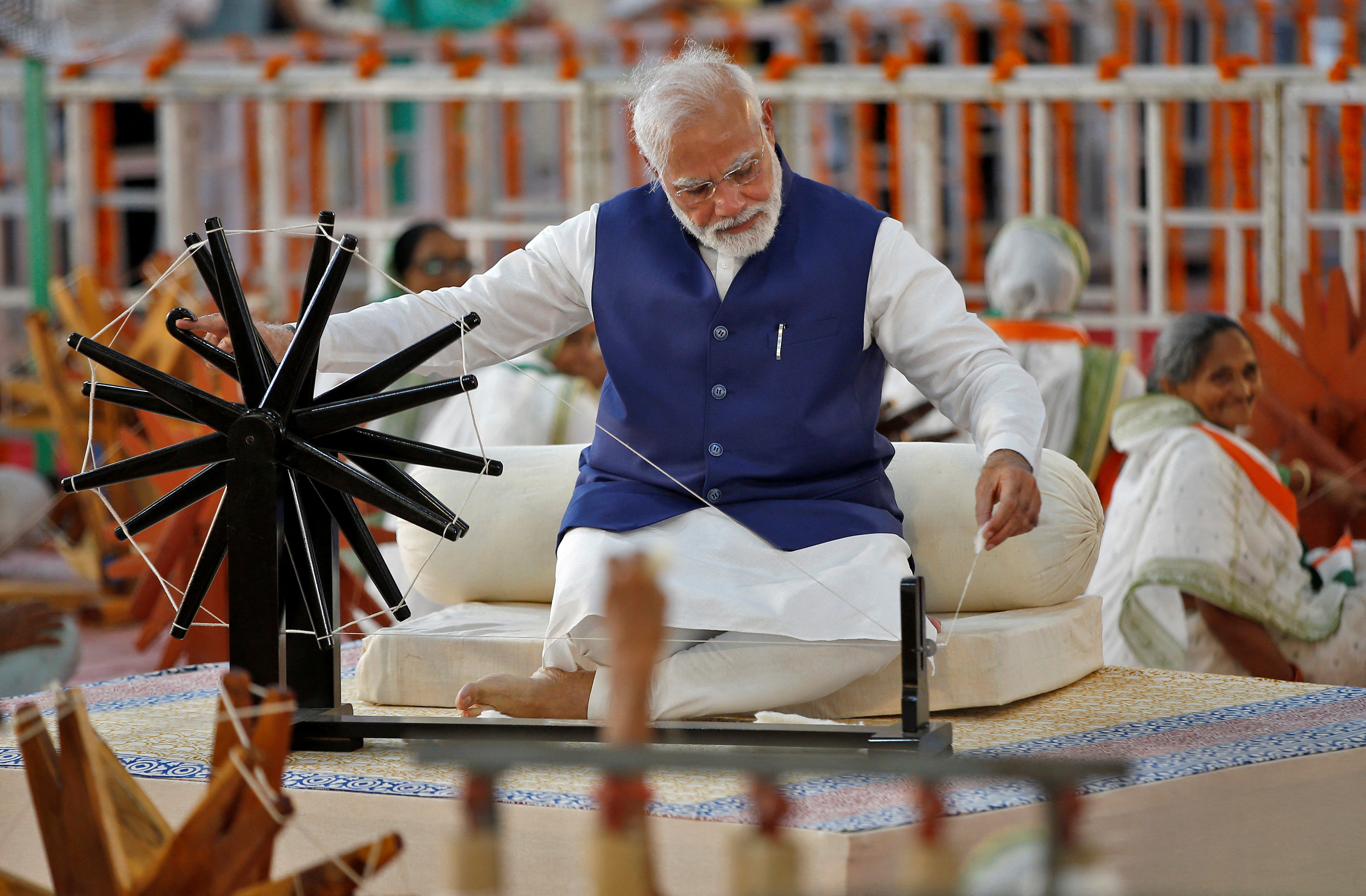 India's Prime Minister Narendra Modi spins cotton on a wheel, in Ahmedabad