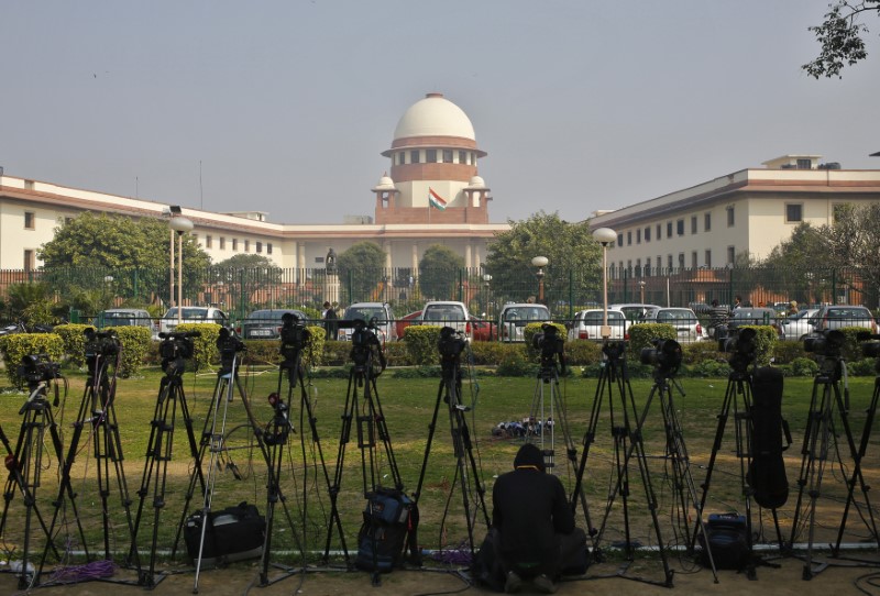 A television journalist sets his camera inside the premises of the Supreme Court in New Delhi February 18, 2014. REUTERS/Anindito Mukherjee