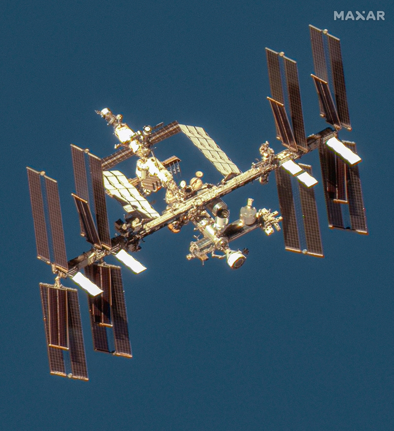 A satellite image shows an overview of the International Space Station with the Boeing Starliner spacecraft