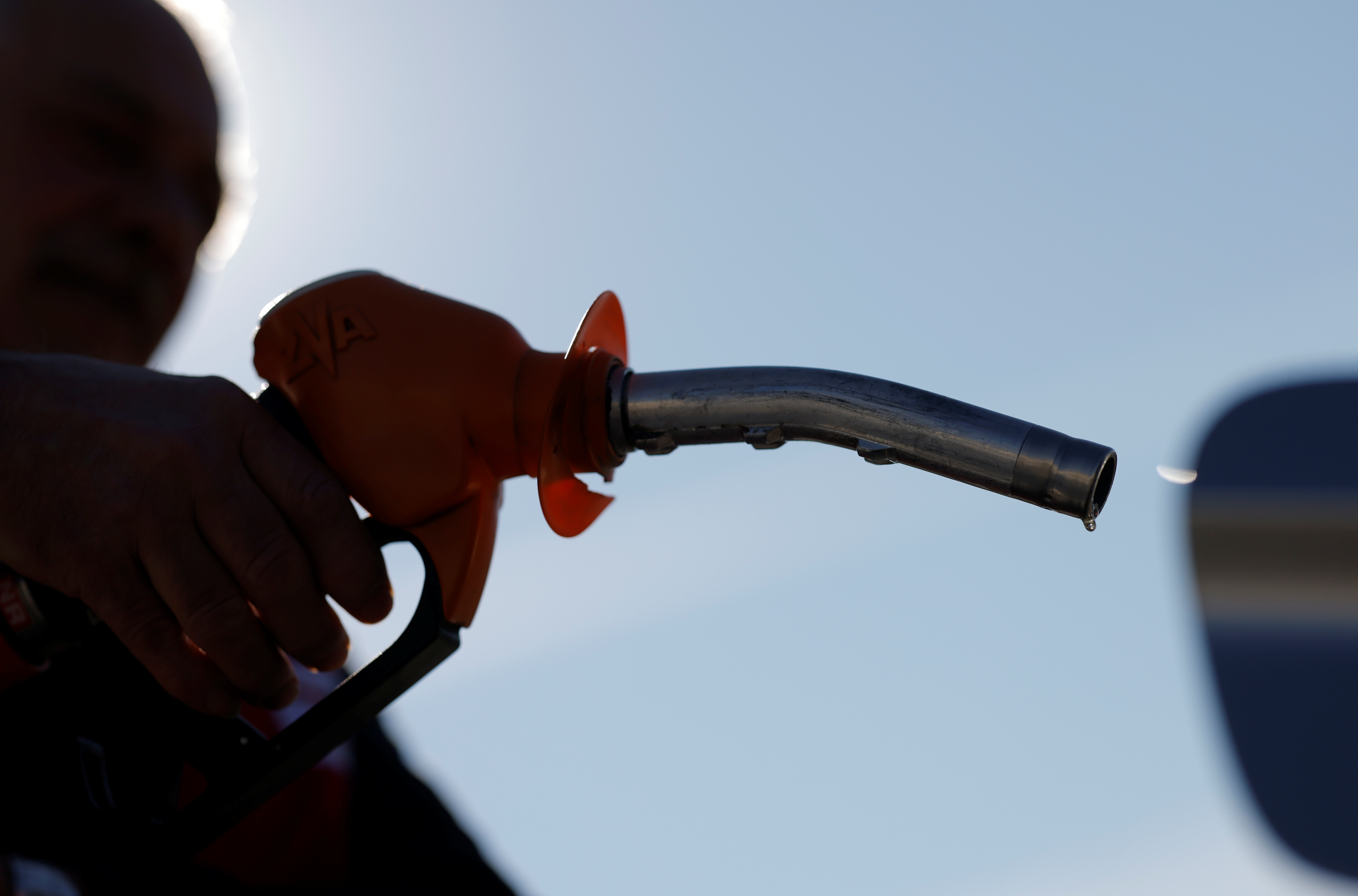A man holds a diesel fuel nozzle at a petrol station in Oree-d'Anjou
