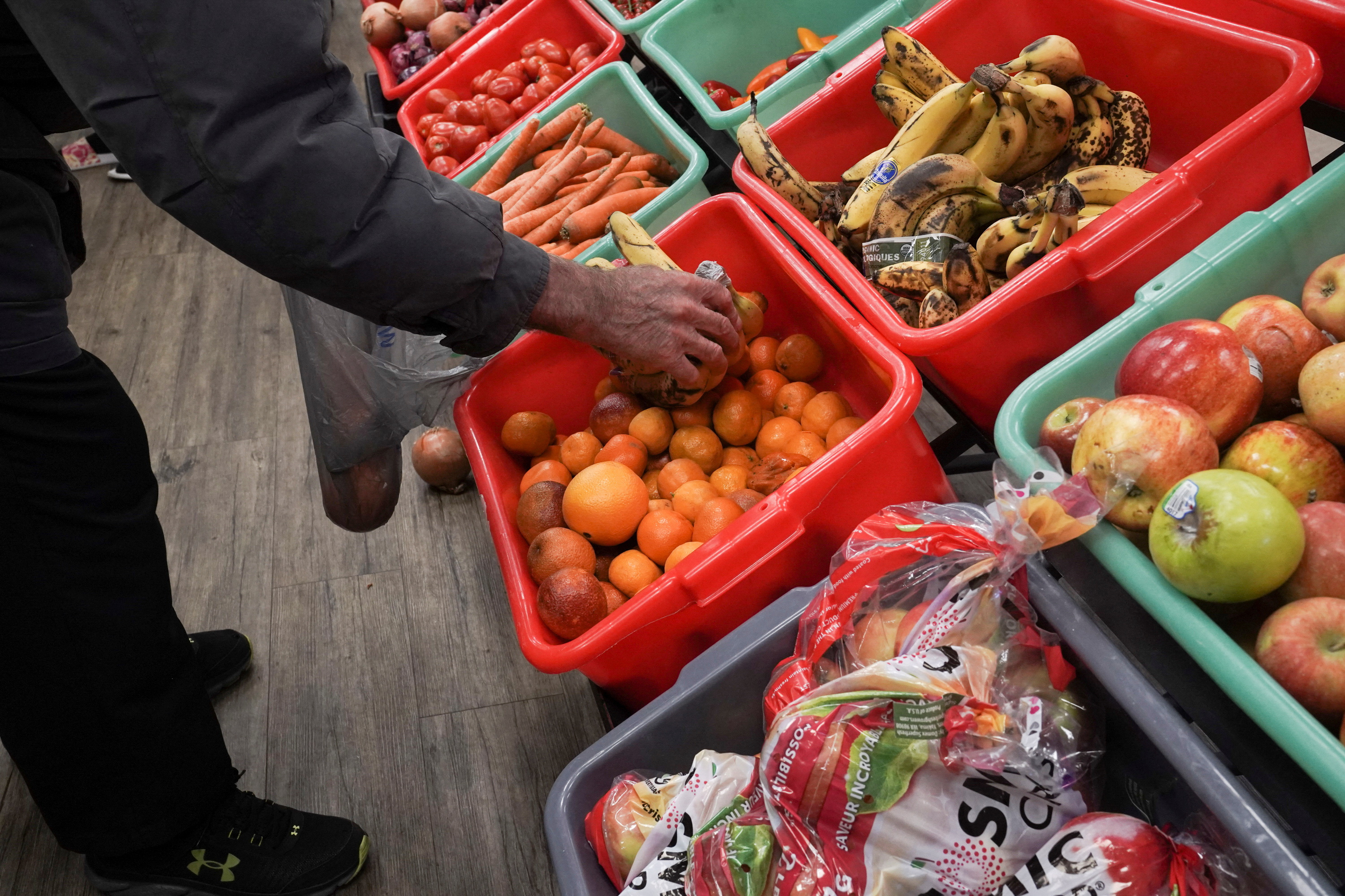 A community member grabs a piece of fruit at The Community Assistance Center food pantry, in Atlanta