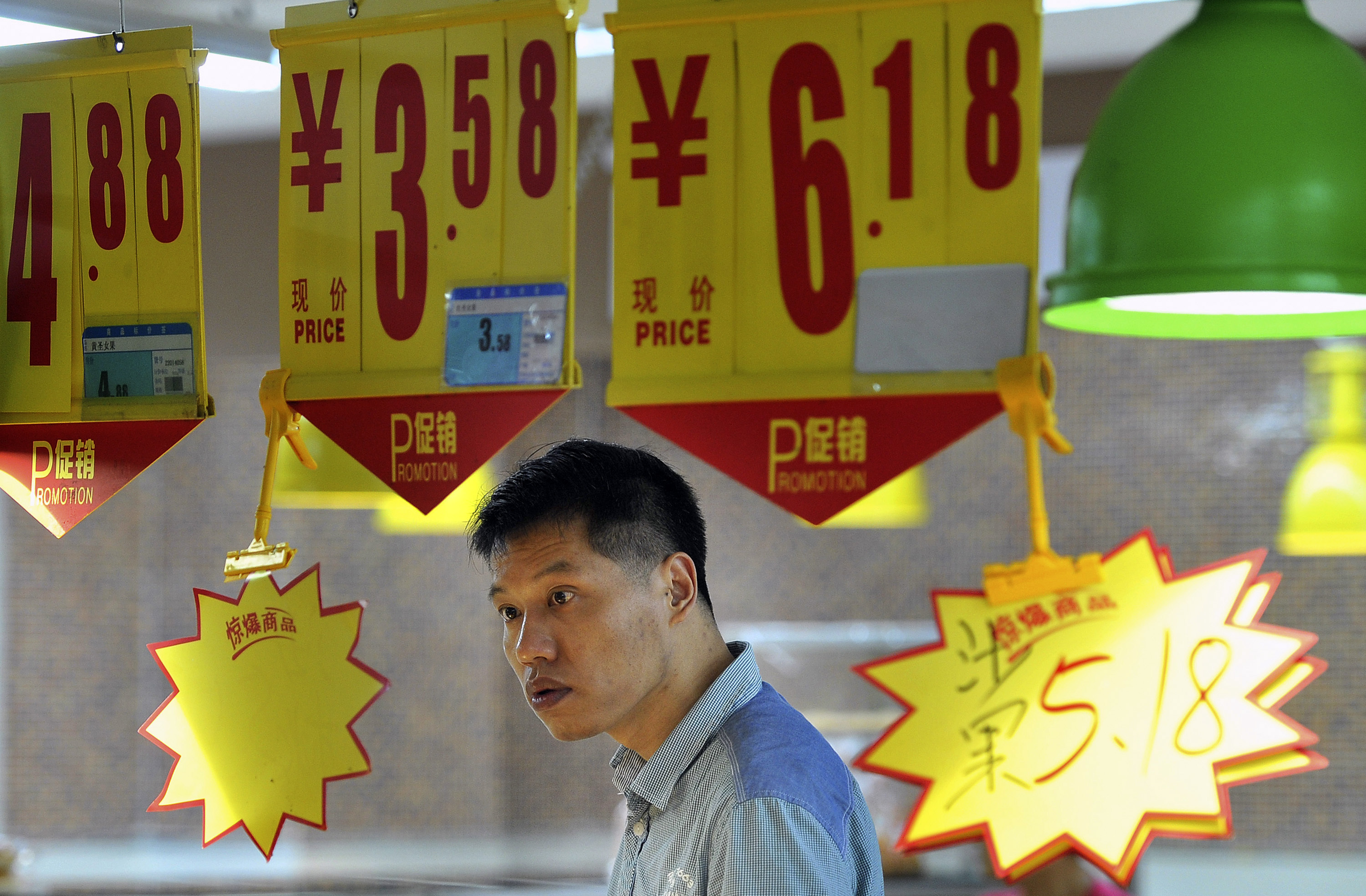 A man looks at a price tag as he shops at a supermarket in Hefei