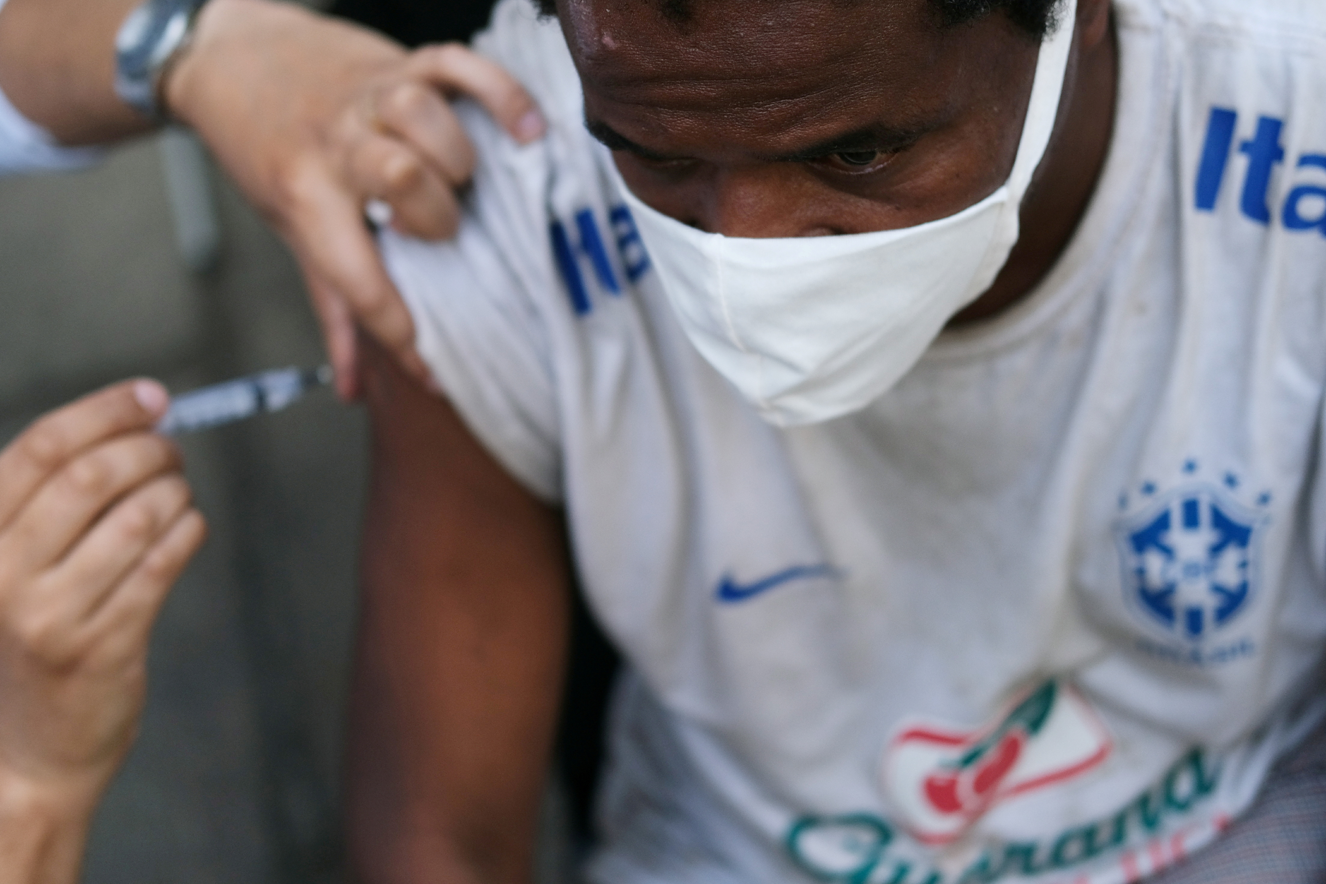 Un agent de santé applique un vaccin contre la maladie à coronavirus d'AstraZeneca (COVID-19) à un citoyen lors d'une campagne de vaccination pour les sans-abri, dans le centre-ville de Rio de Janeiro, au Brésil, le 27 mai 2021. REUTERS/Ricardo Moraes