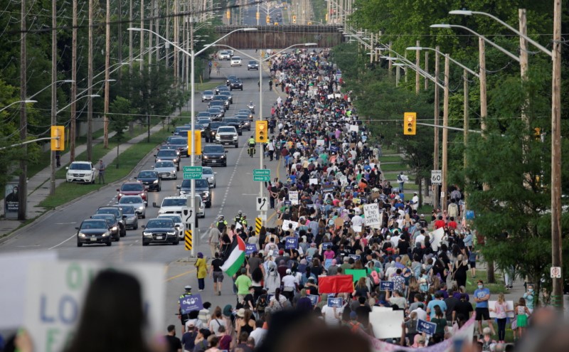 People march the 7km from a crime scene to a mosque in memory of a Muslim family that was killed in what police call a hate-motivated attack in London, Ontario