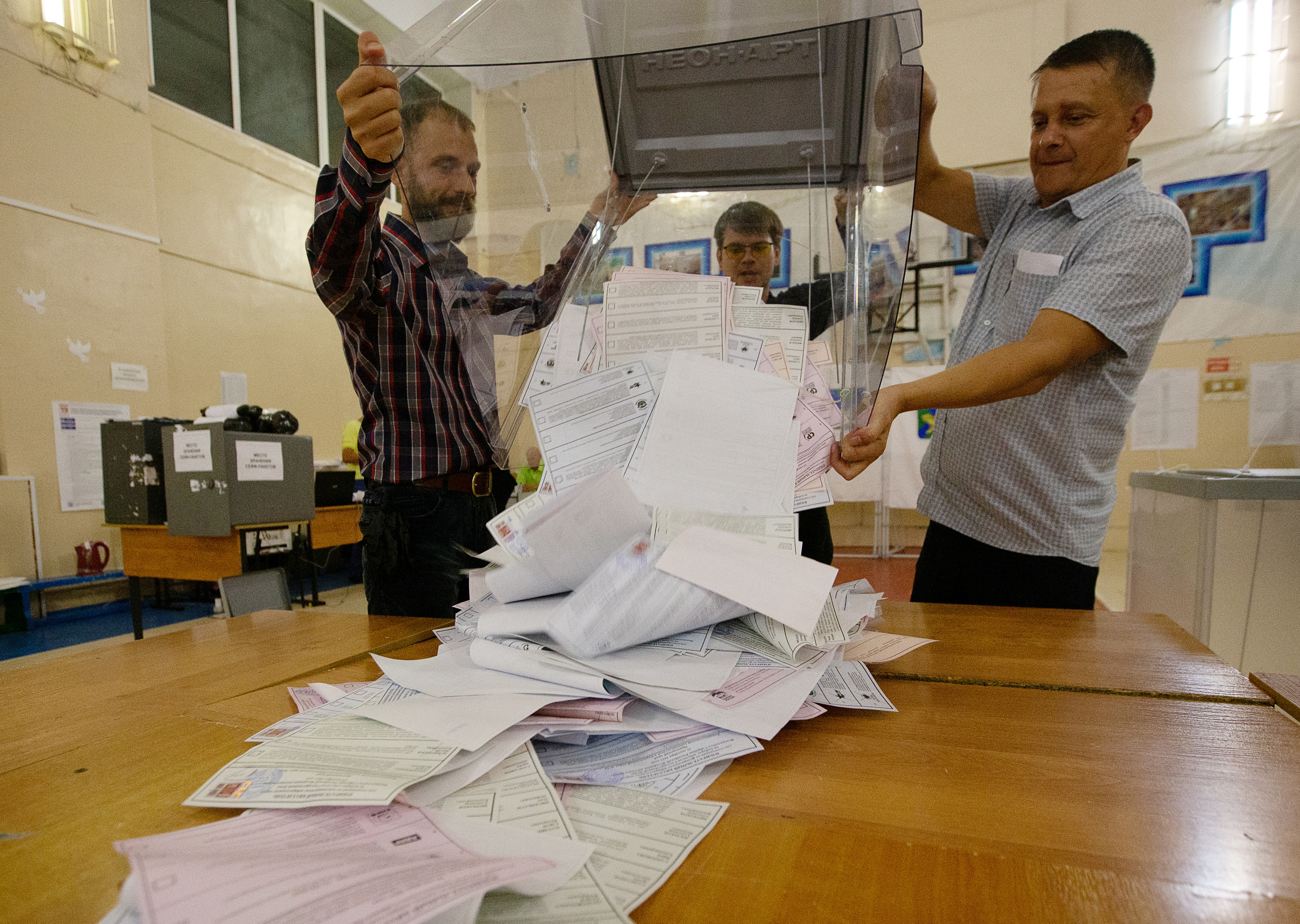 Members of a local election commission empty a ballot box before starting to count votes during a three-day parliamentary election in the far eastern city of Vladivostok, Russia September 19, 2021. REUTERS/Tatiana Meel NO RESALES. NO ARCHIVES