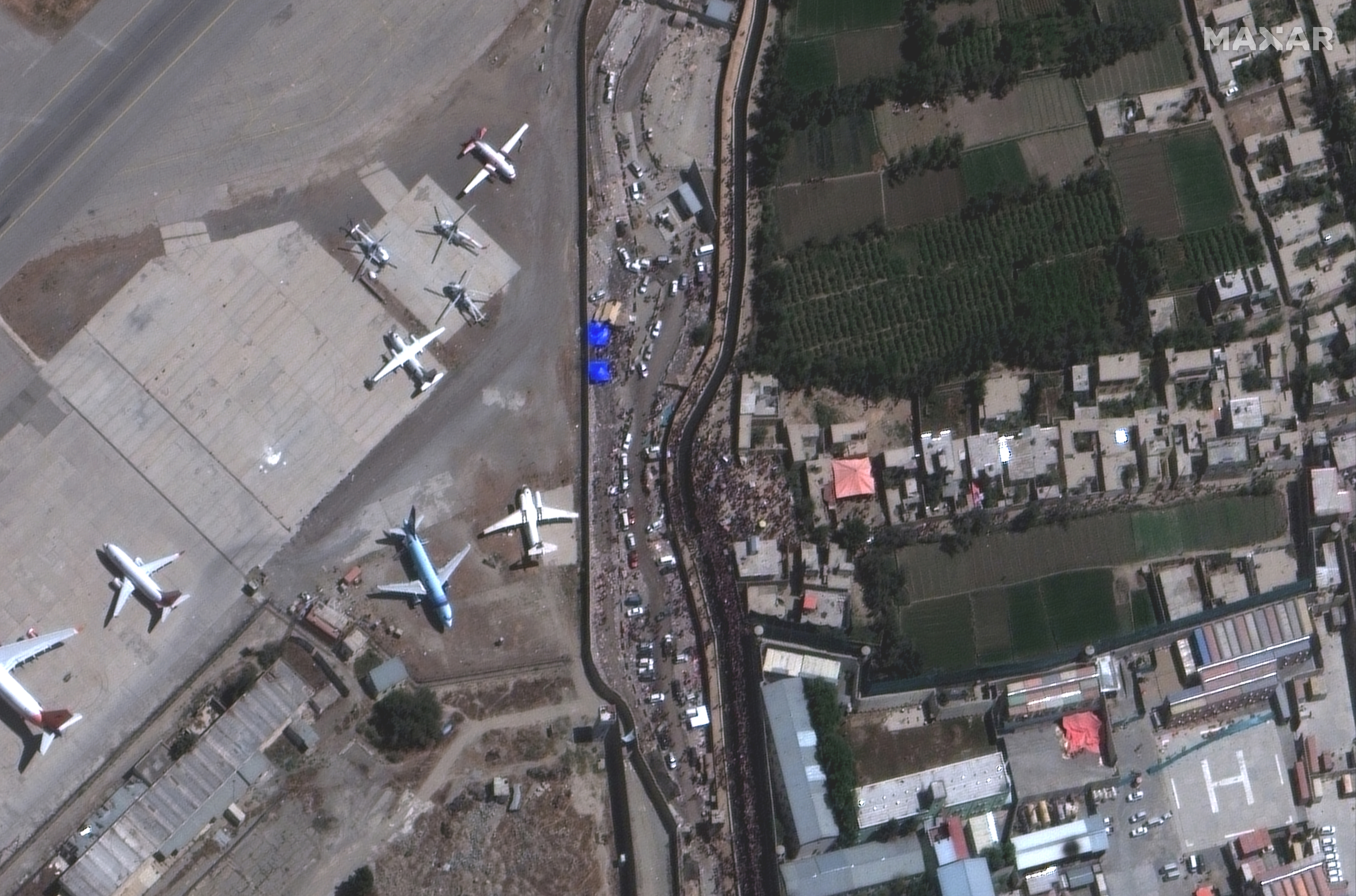 An overview of crowds at the Abbey Gate at Hamid Karzai International Airport, in Kabul, Afghanistan August 24, 2021, in this satellite image obtained by Reuters on August 26, 2021.  Satellite image 2021 Maxar Technologies/Handout via REUTERS.