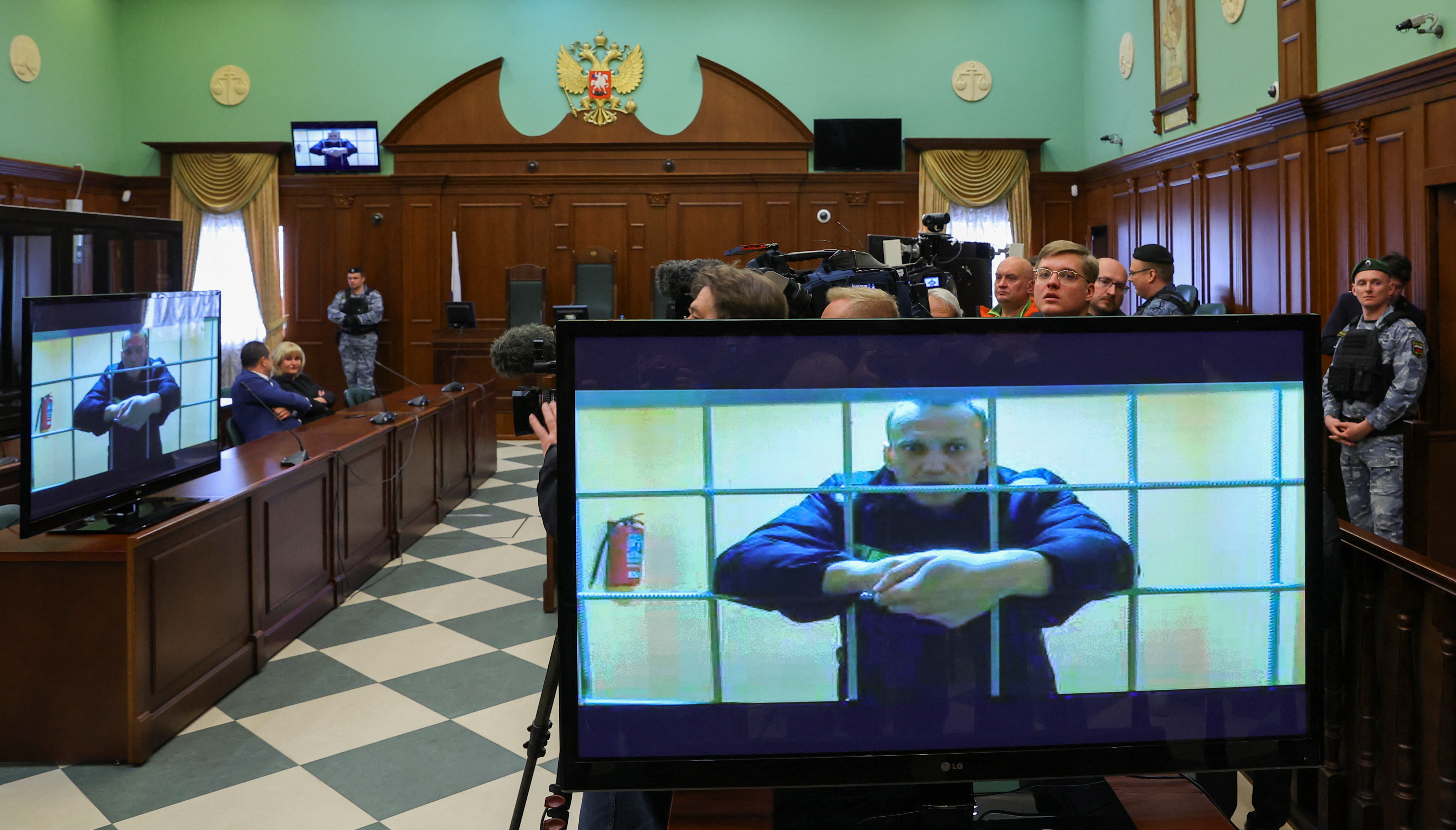 Jailed Russian opposition leader Alexei Navalny is seen on screens during a court hearing in Moscow