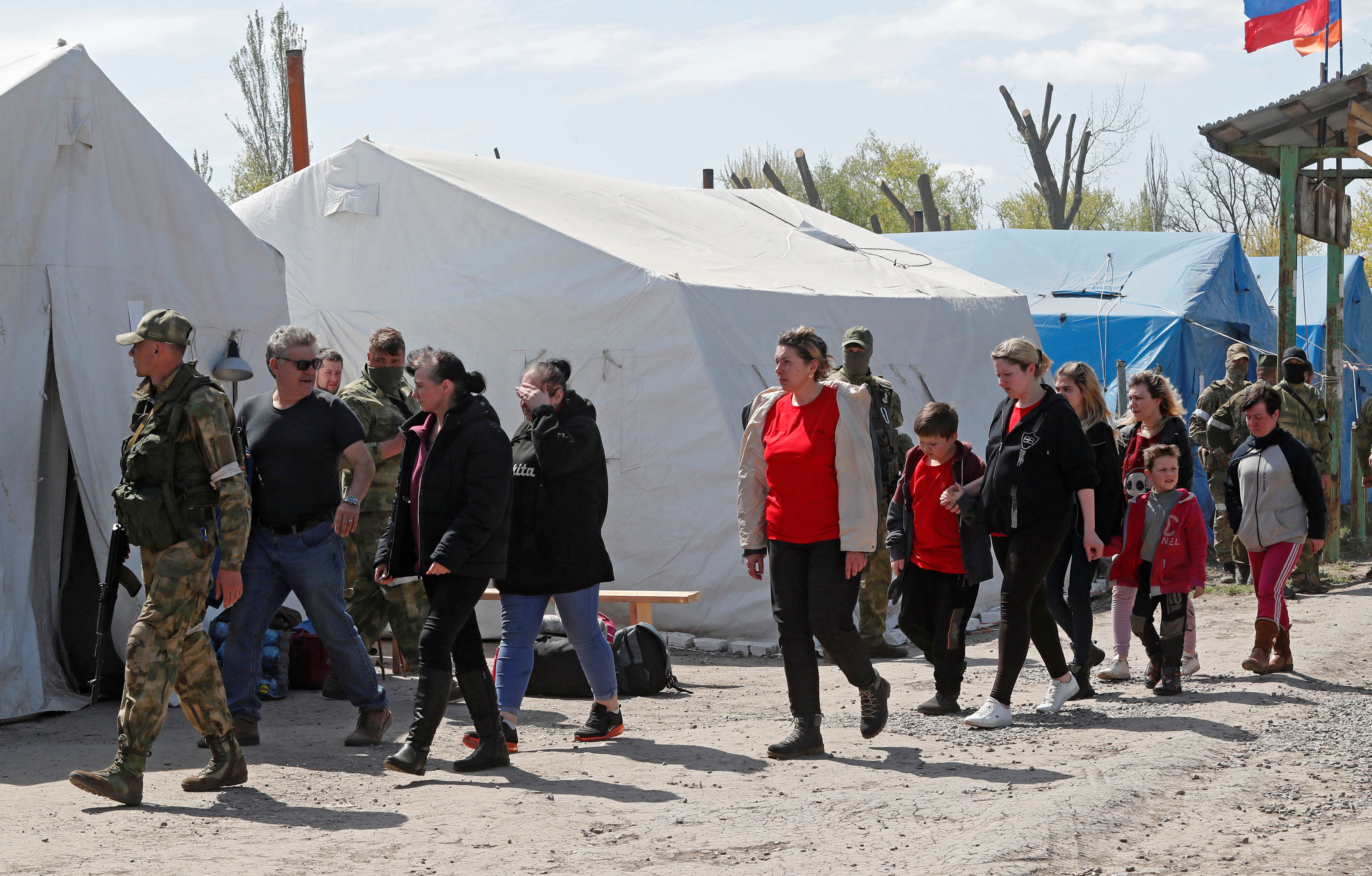 Civilians who left the area near Azovstal steel plant in Mariupol walk at a temporary accommodation centre in Bezimenne