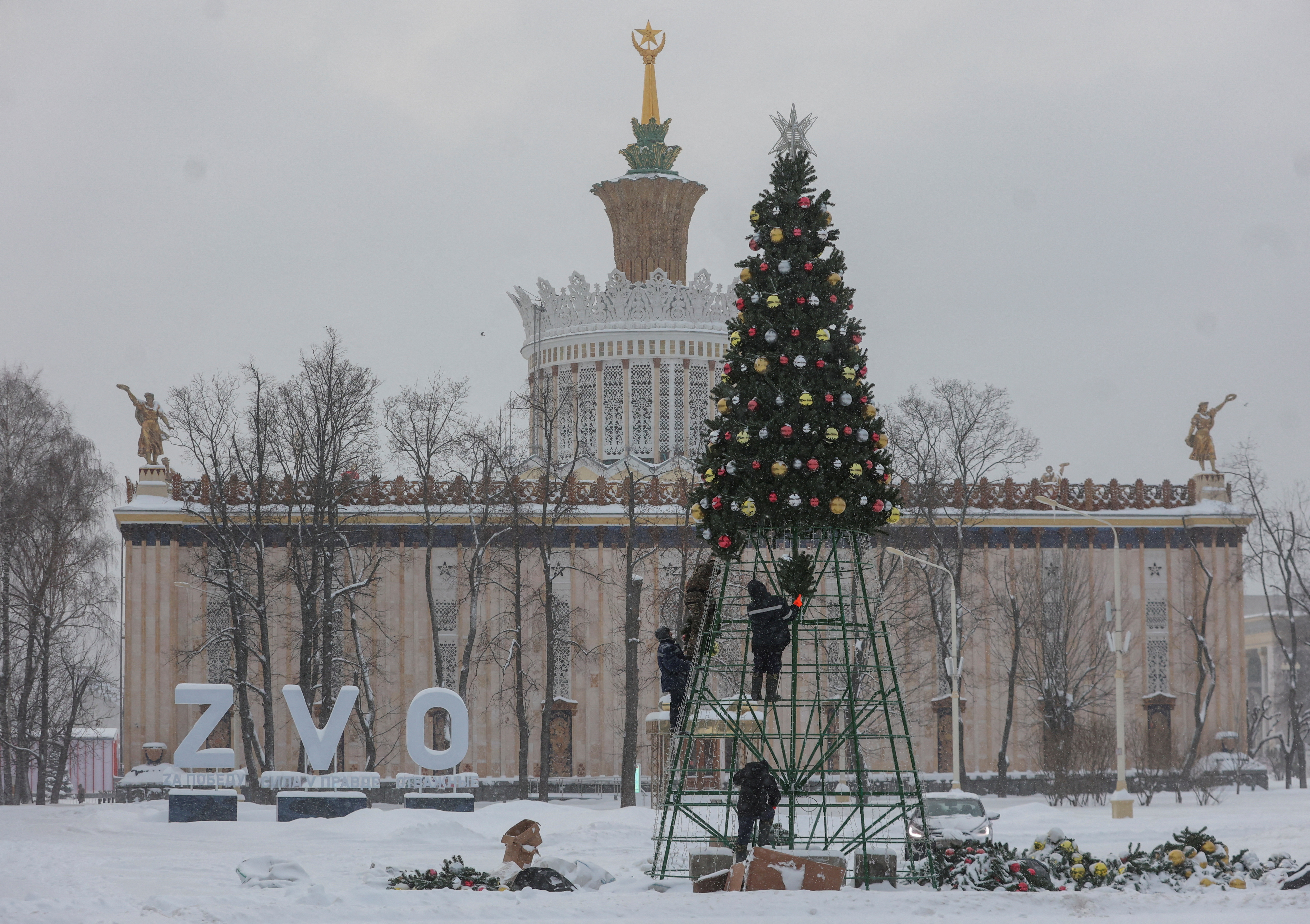 Workers install Christmas and New Year decorations during snowfall at the Exhibition of Achievements of National Economy (VDNKh) in Moscow