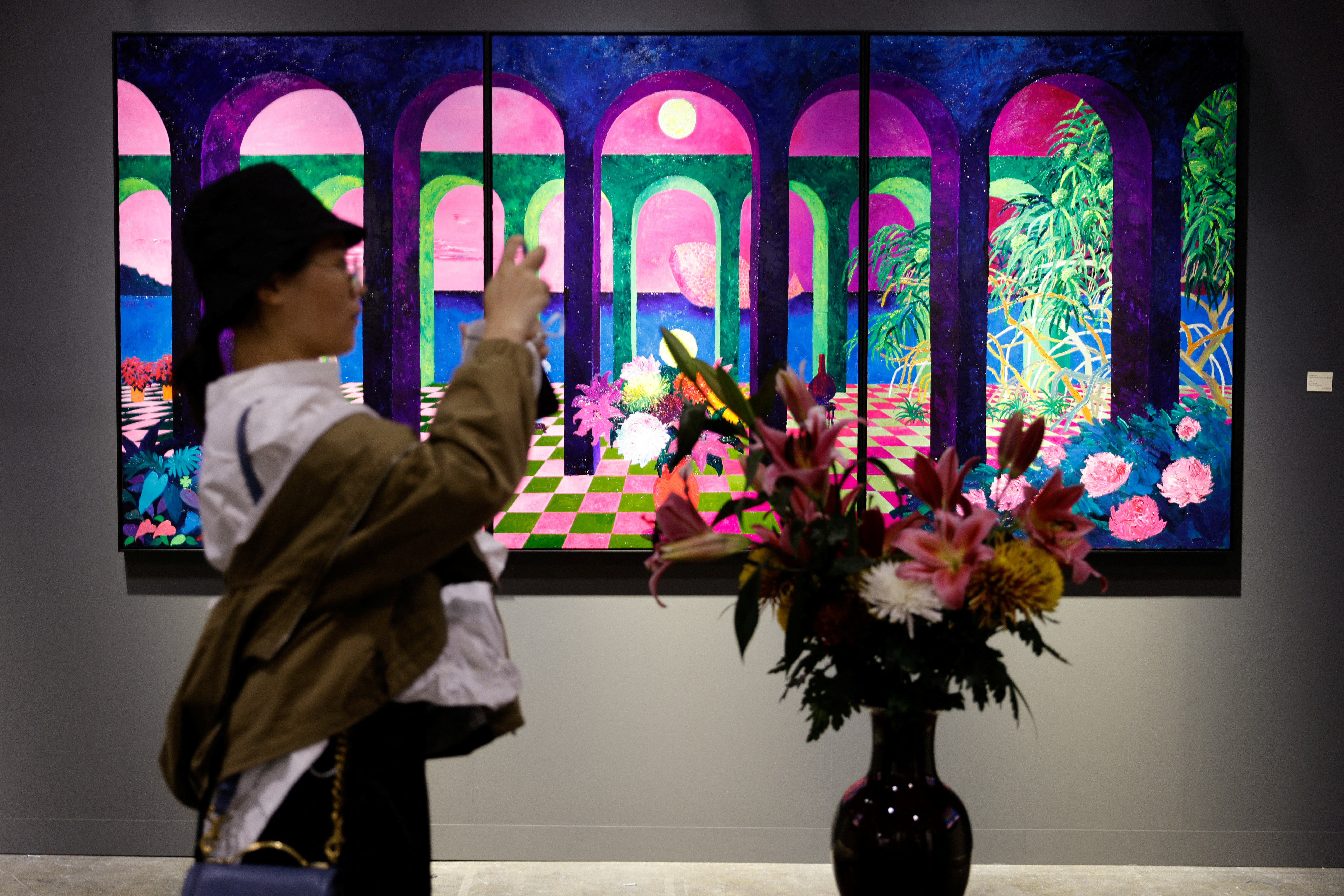 A woman takes photo in front of an artwork titled "Ode to Wandering Son" by William Lim at Art Basel in Hong Kong