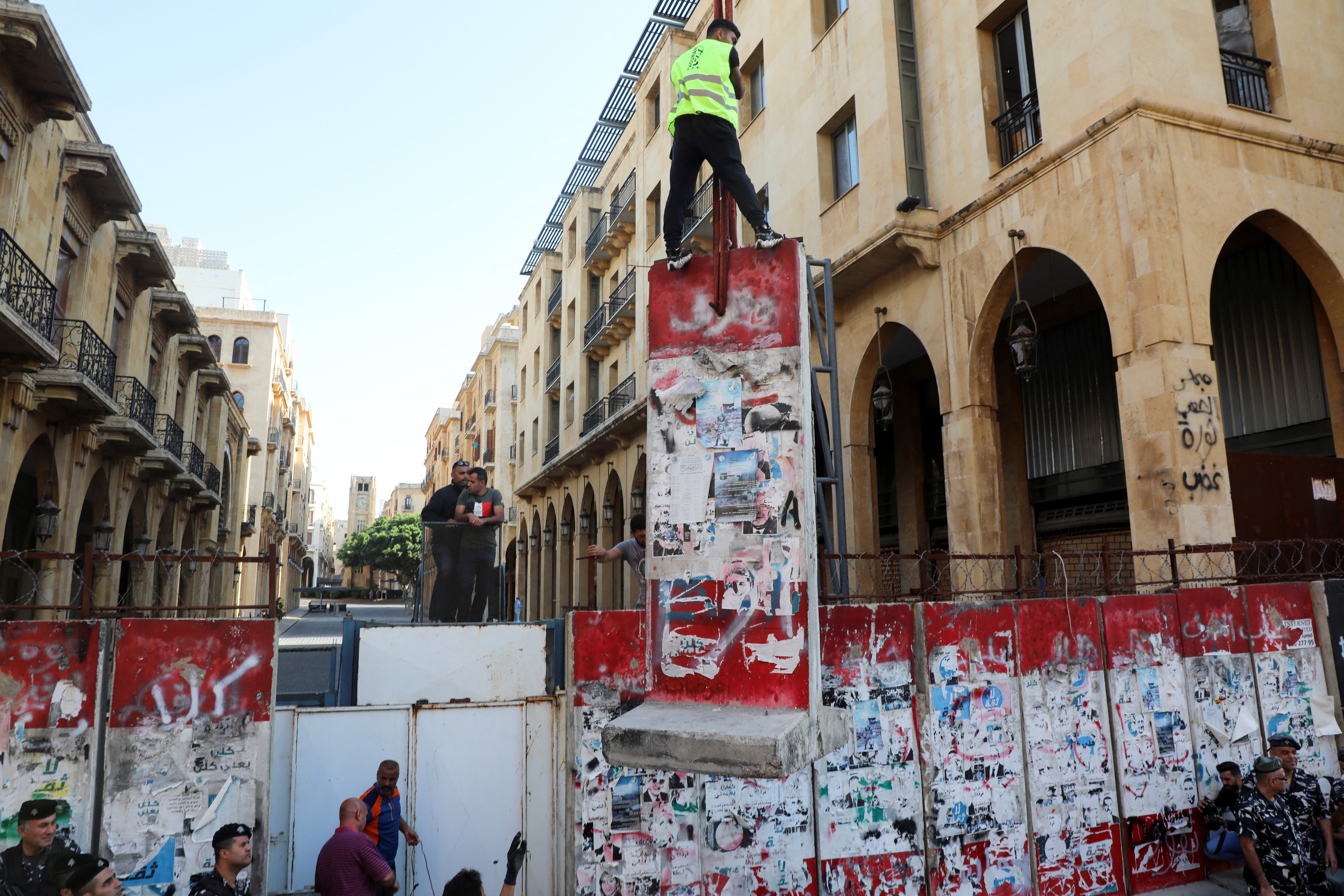 People remove a concrete barrier blocking a street leading to the Parliament building in Beirut