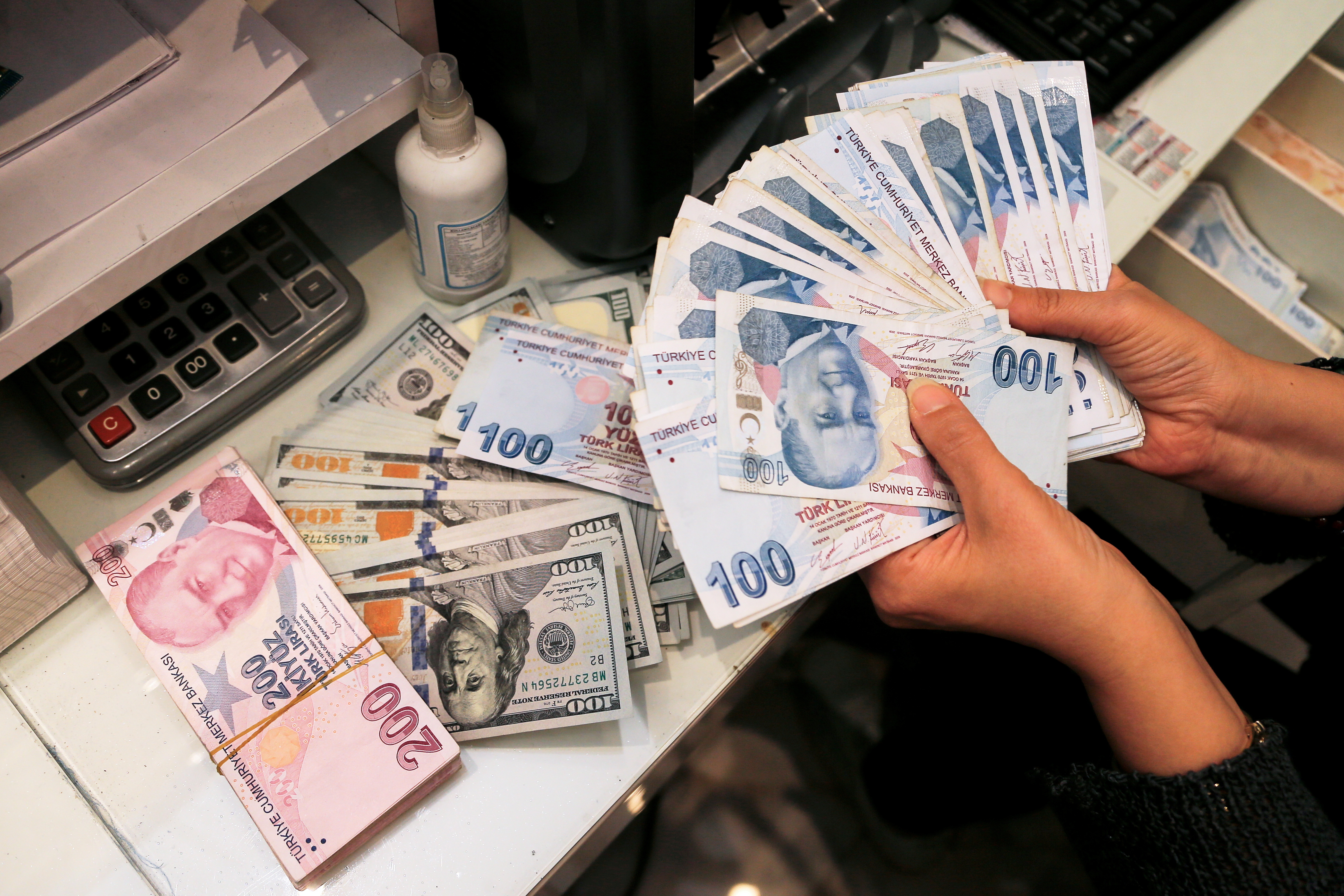 A money changer holds Turkish lira banknotes at a currency exchange office in Ankara, Turkey October 12, 2021. REUTERS/Cagla Gurdogan/File Photo