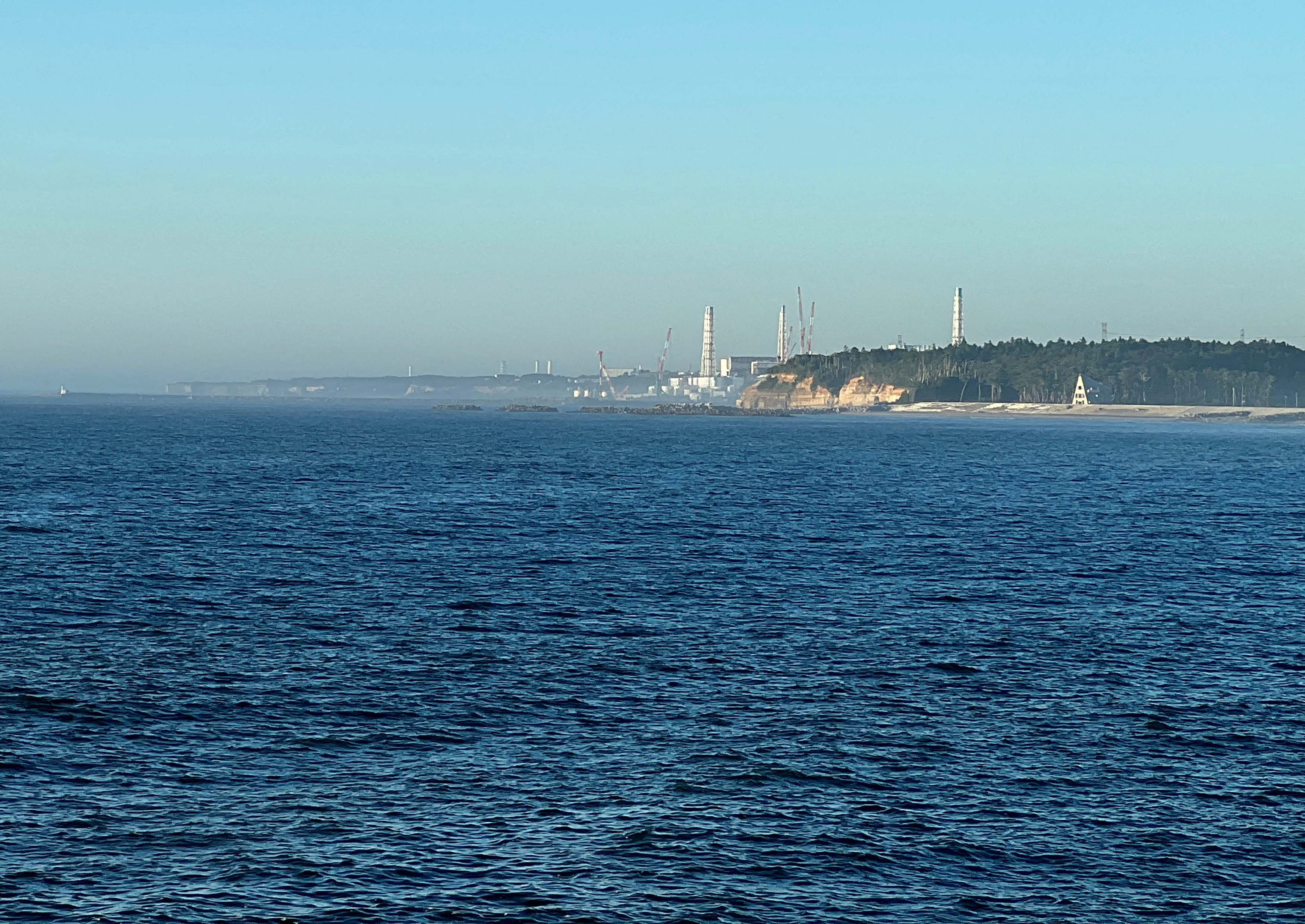 Nami kasabasındaki yakındaki balıkçı limanı Okido'dan Fukushima Daiichi Nükleer Santrali'nin görünümü