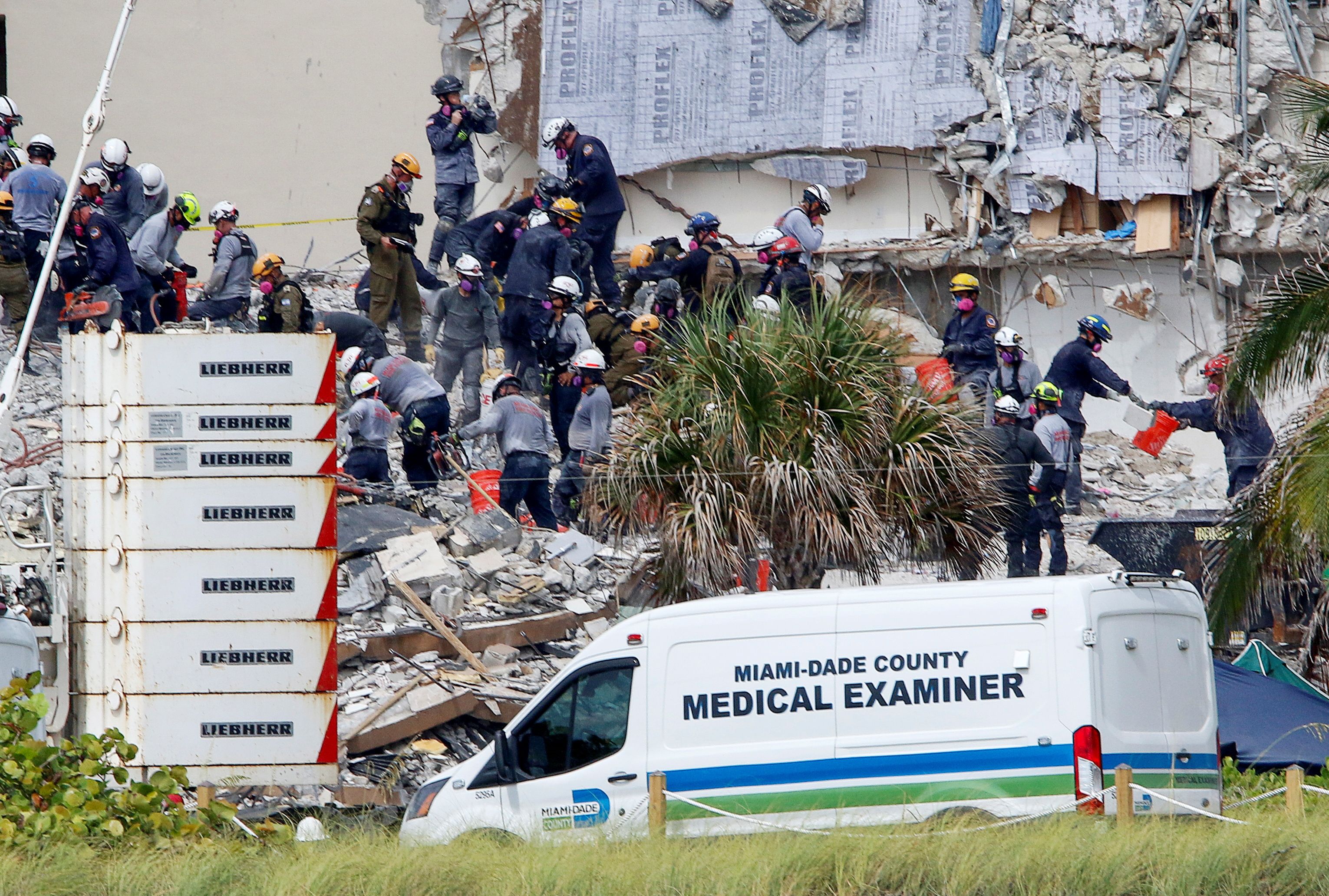 Emergency workers conduct search and rescue efforts at the site of a partially collapsed residential building in Surfside
