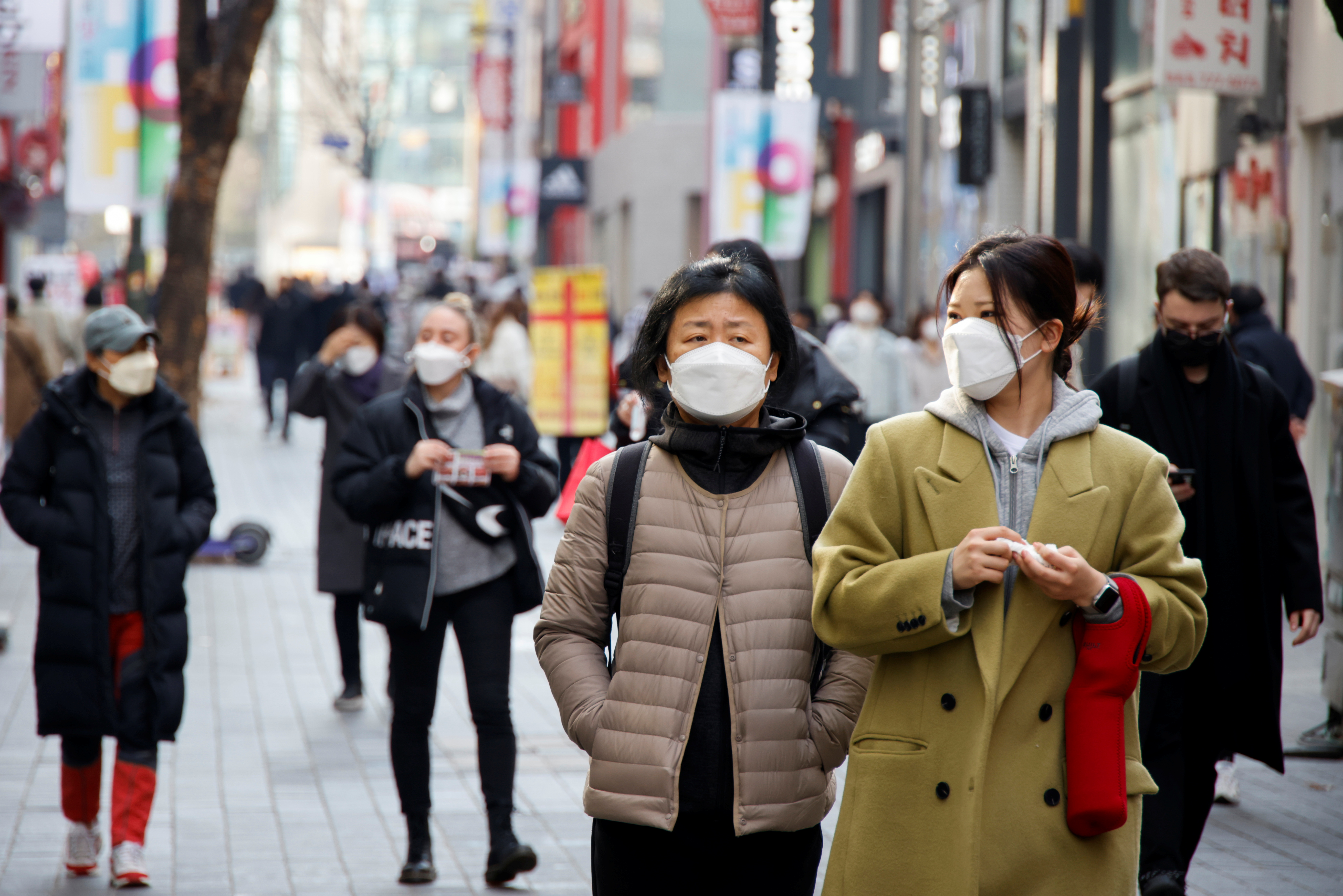 Women wearing masks walk in a shopping district amid the coronavirus disease (COVID-19) pandemic in Seoul, South Korea, November 29, 2021. REUTERS/Heo Ran/file photo