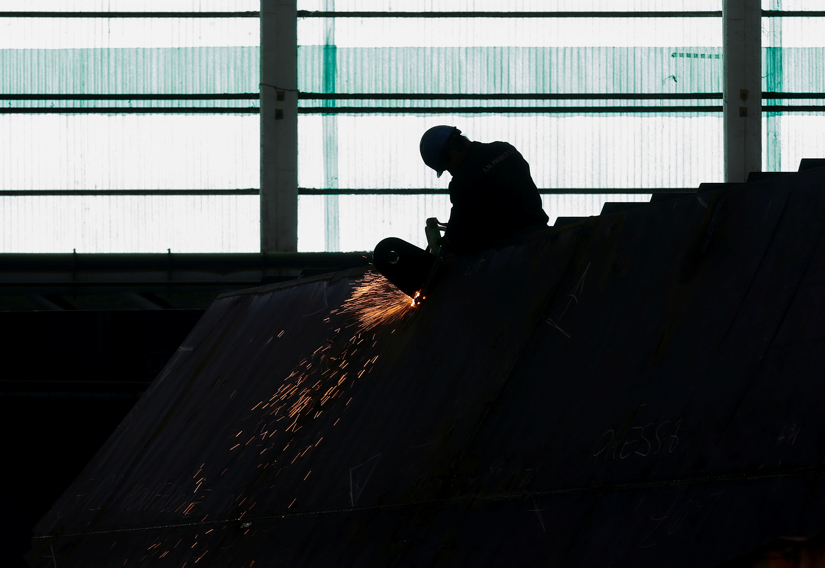 A worker of Italian shipbuilding Fincantieri solders steel at Monfalcone shipyard near Trieste