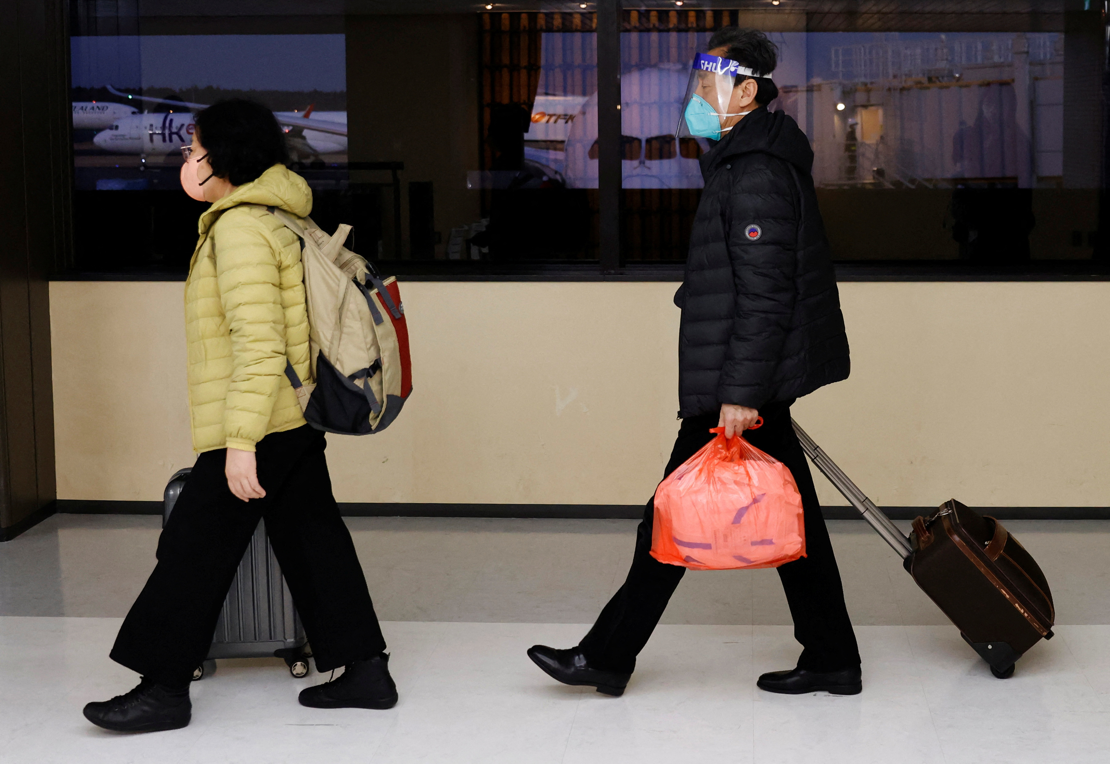 Passengers of a plane from Dalian in China, head to the coronavirus disease (COVID-19) test area upon their arrival at Narita international airport